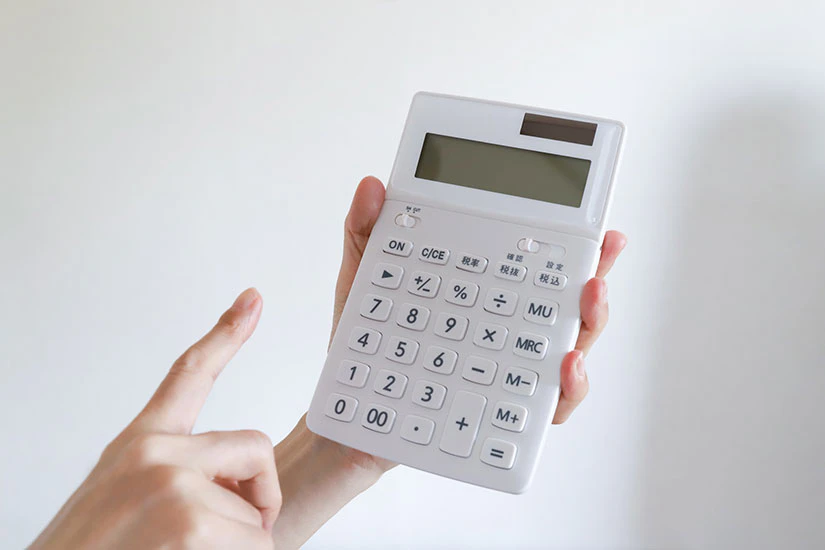 白い計算機を使う手元の写真