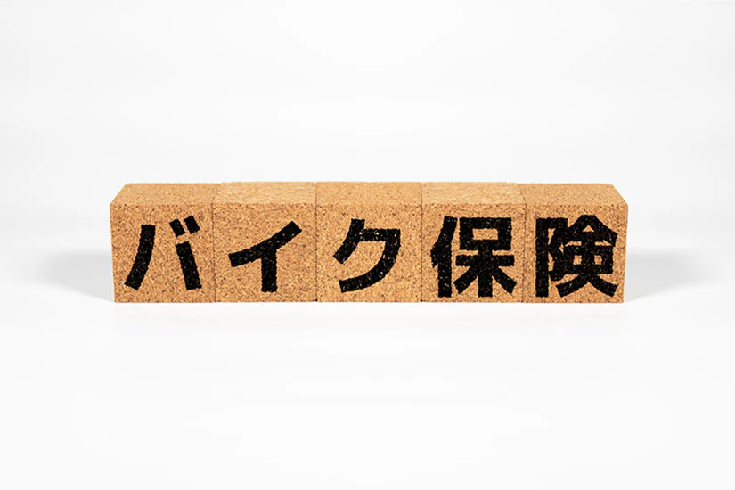バイク保険と書かれたコルク素材のブロック
