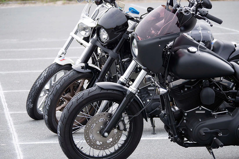 駐車場に大型バイクが3台並んでいる写真。