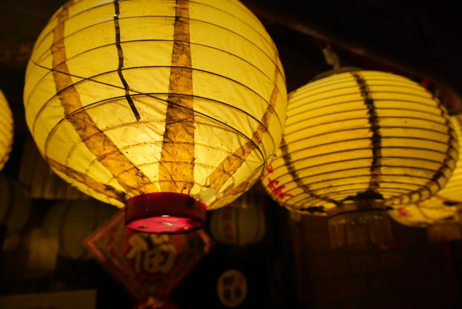 夜に灯りがともった黄色い提灯を近くから撮影した写真