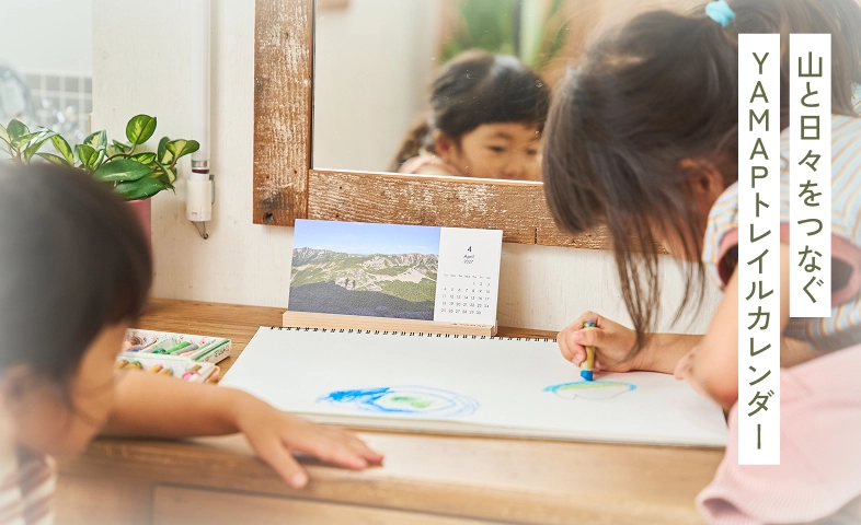 卓上のトレイルカレンダーを見ながらお絵かきをする子どもたち