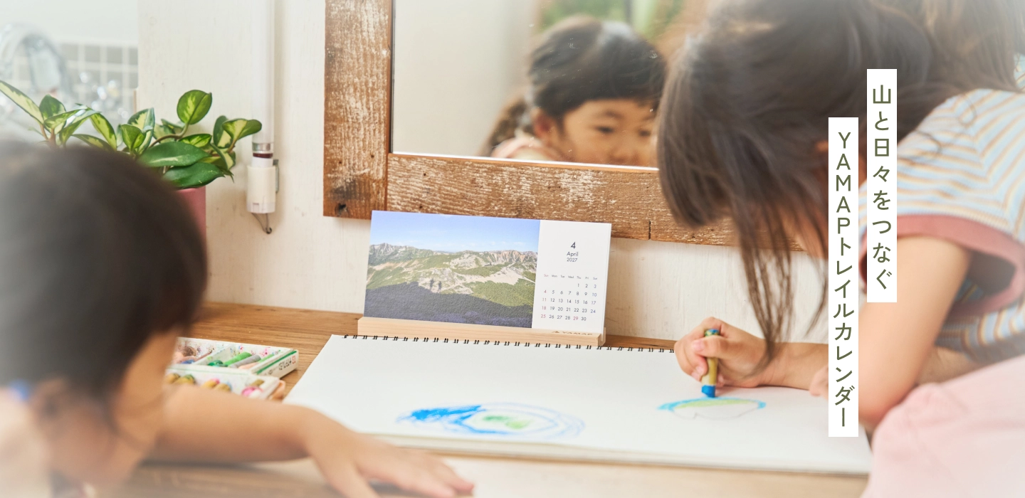 卓上のトレイルカレンダーを見ながらお絵かきをする子どもたち