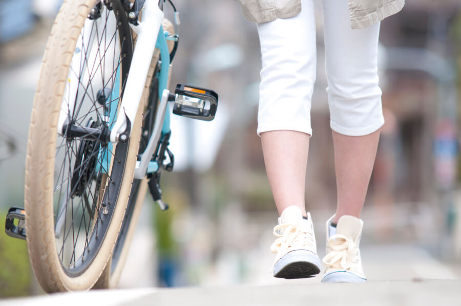 自転車をひいて歩く妊婦