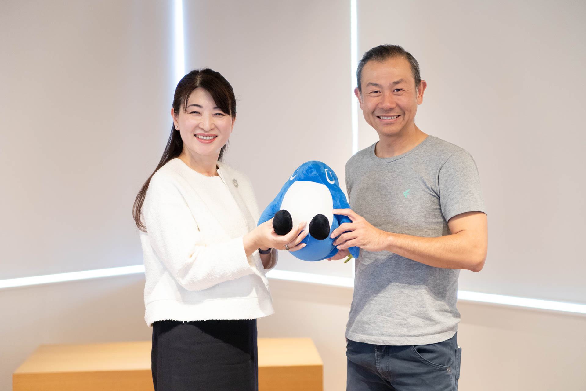 freee公式キャラクターsweeeを中央に持ち微笑む、freee CEO佐々木大輔と国立大学法人一橋大学　副学長／スタートアップ支援室長　西野和美 氏