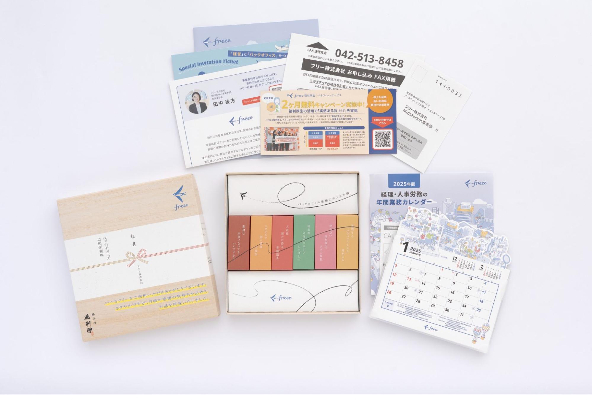 第40回全日本DM大賞 銅賞受賞「粗品羊羹DM」。木箱風のパッケージに「粗品」の熨斗がかかった羊羹セットと、2025年版の経理・人事労務の年間業務カレンダー、キャンペーン案内などの同封物一式。羊羹の個包装には「入社に合う」「精算し直してほしい」などバックオフィス業務の本音がデザインされている。
