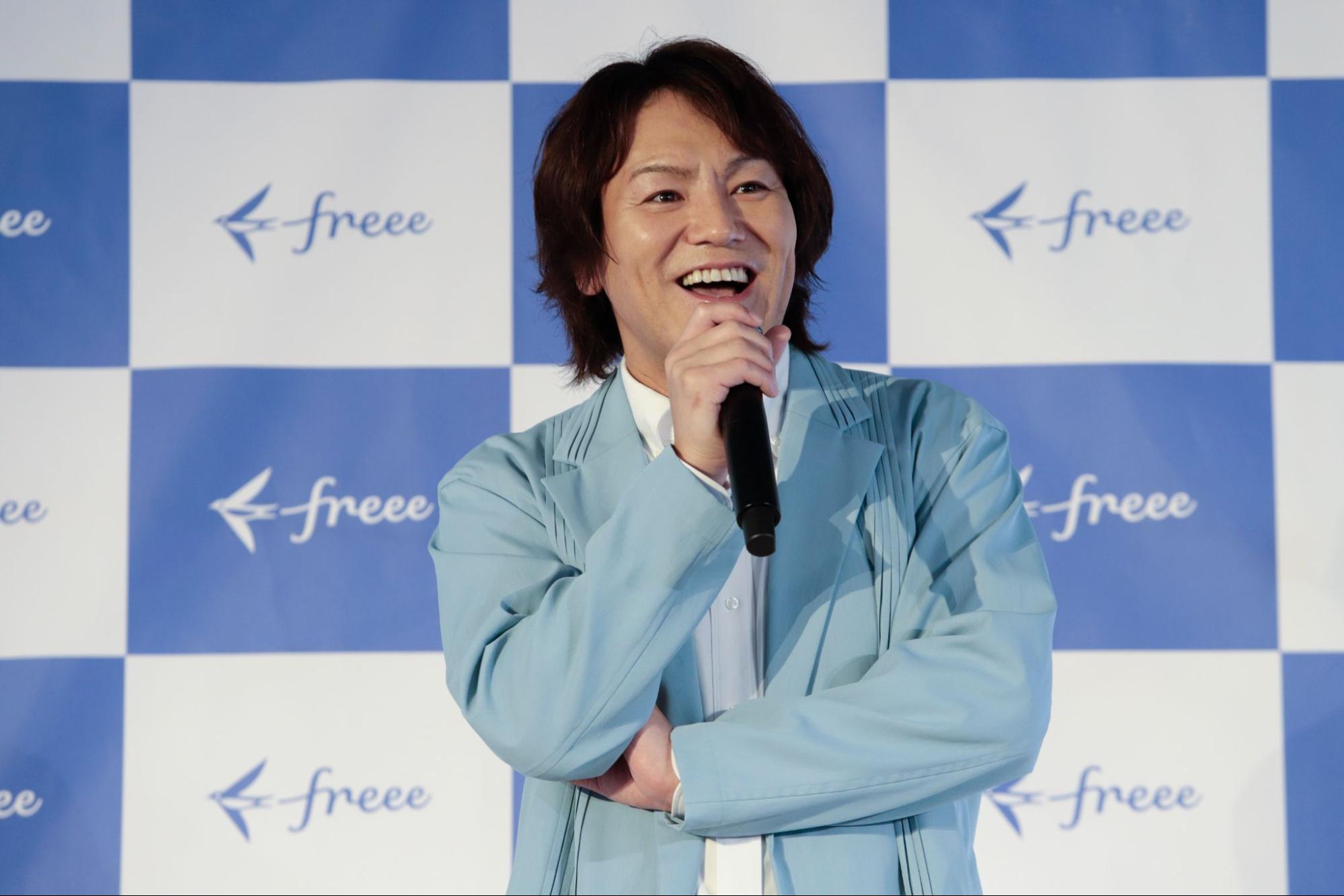 マイクを持ちにこやかに話をする狩野英孝 氏