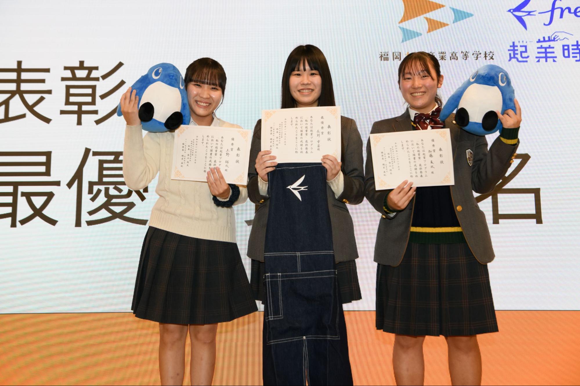 受賞した生徒3人の集合写真。左から、優秀賞：上野結衣さん（3年）　起業案：メイクのサブスク「chou chou Box」、最優秀賞：長野幸芽さん（3年）   起業案：ペット見守りサービス「おしらせふれんず」、優秀賞：加藤美玖さん（3年）   起業案：電池式完全防水補聴器「アクアタフ」集合写真