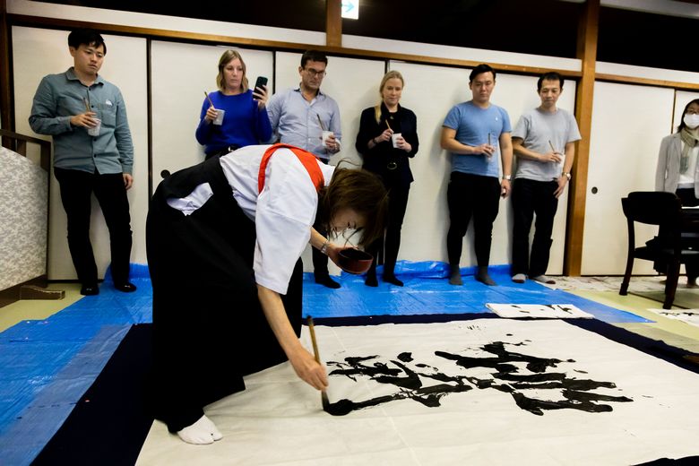 The guests watched the instructor masterfully demonstrate the art of shodo calligraphy.