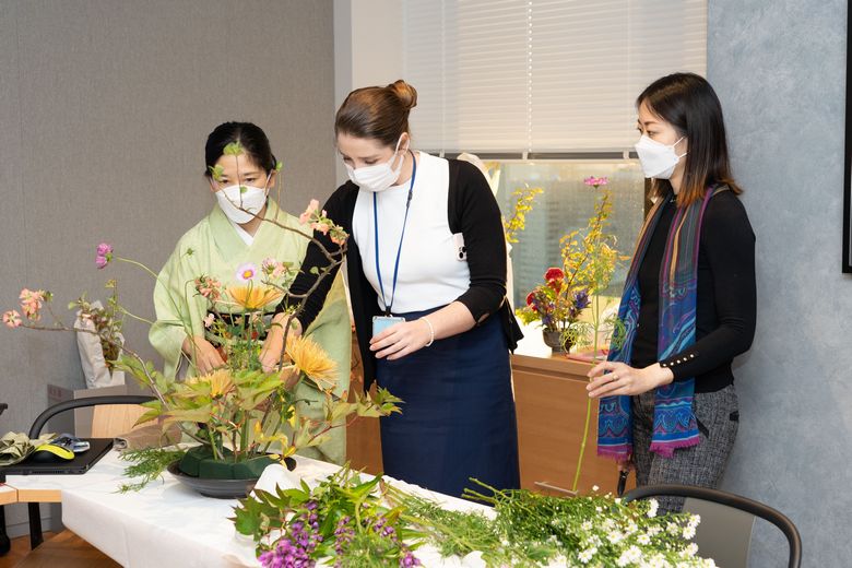 悩みながら花や植物を生けていく参加者