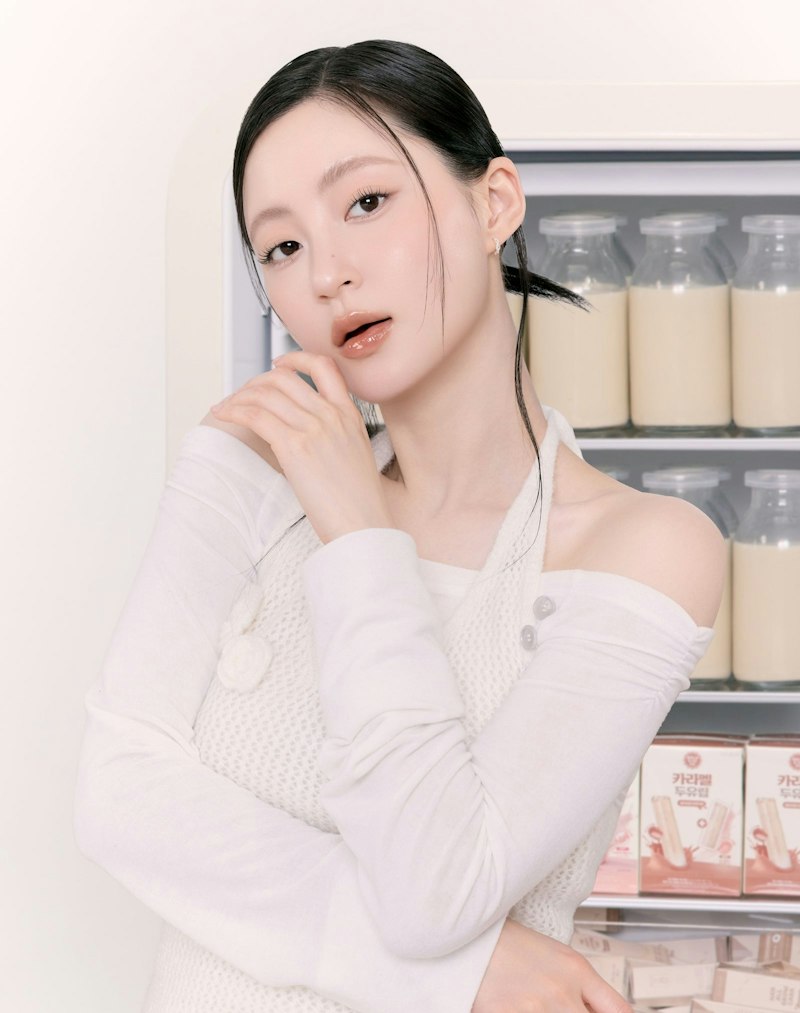 rom&nd(ロムアンド) ロムアンド 豆乳エディション ザジューシーラスティングティントセット(豆乳ボトルの並ぶ冷蔵庫前でポーズをとるモデルのリップメイクイメージ)