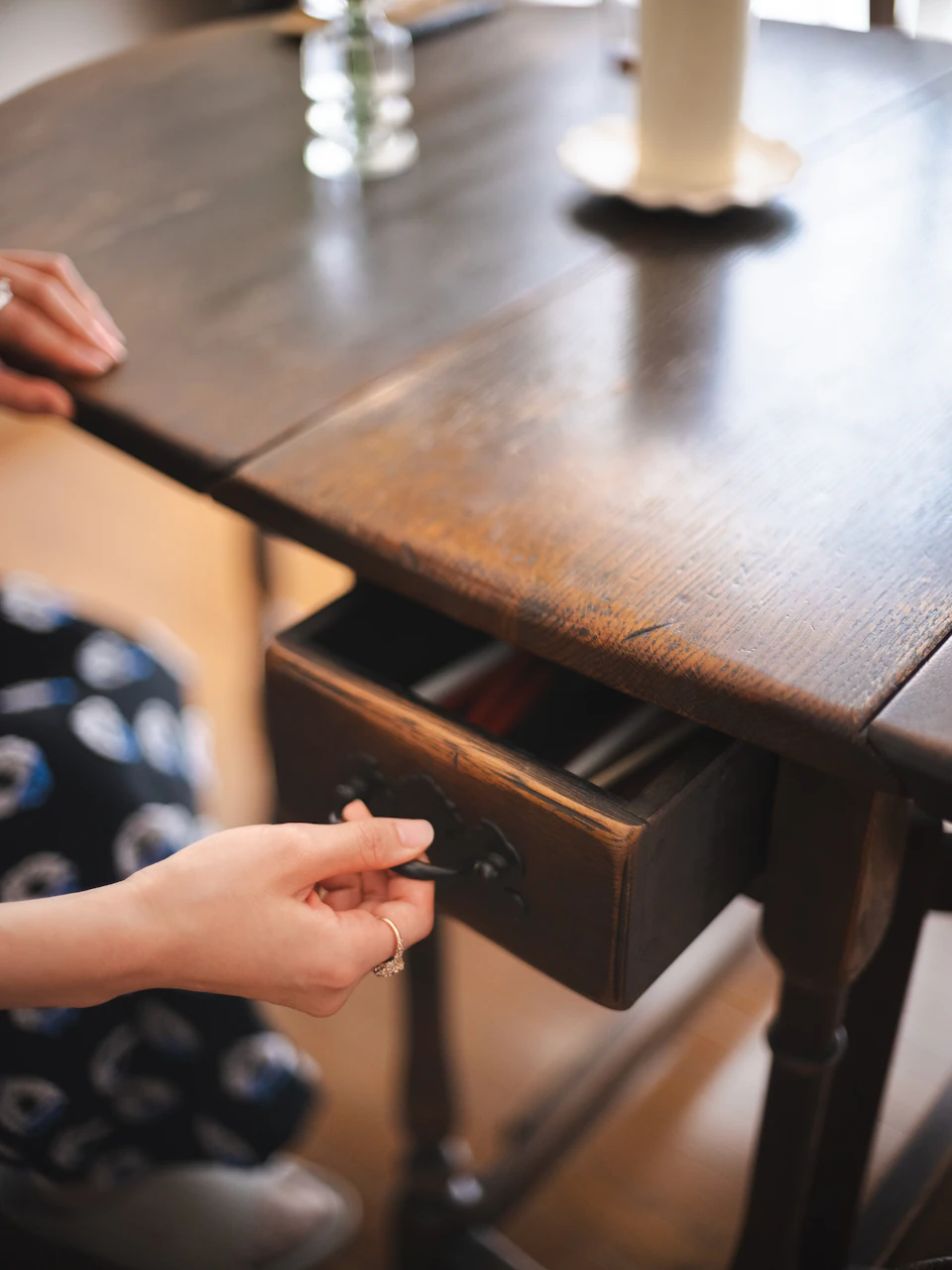 ダイニングテーブルの引き出しを、アンティーク調の取手を軽く引いて開けて見せる石山さん。
