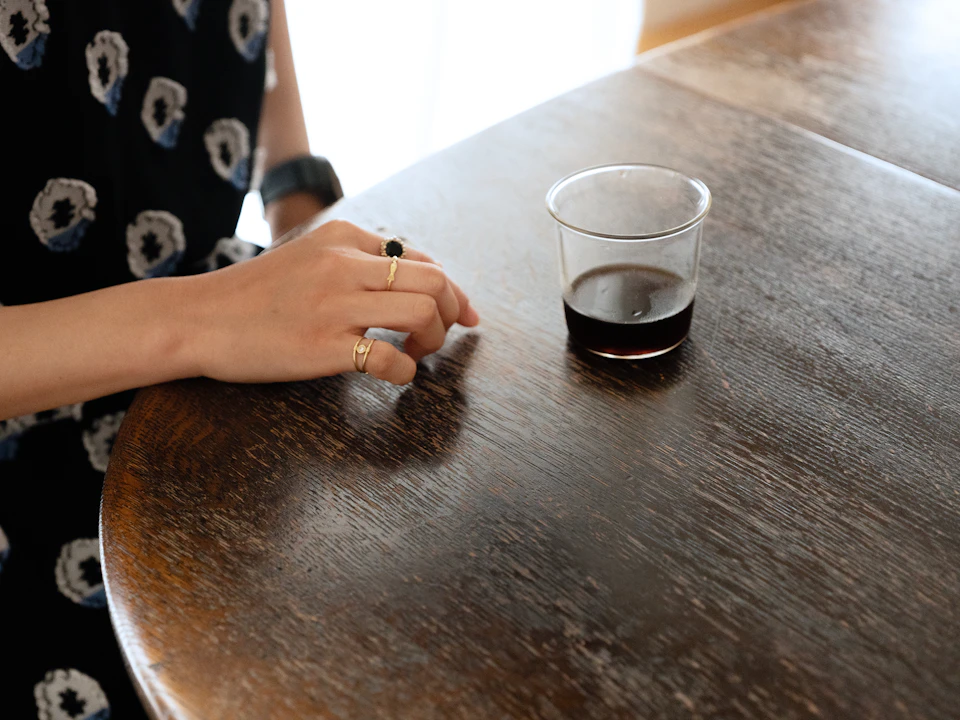 年季の入ったダイニングテーブルの表面を、指で撫でるような仕草をする石山さん。