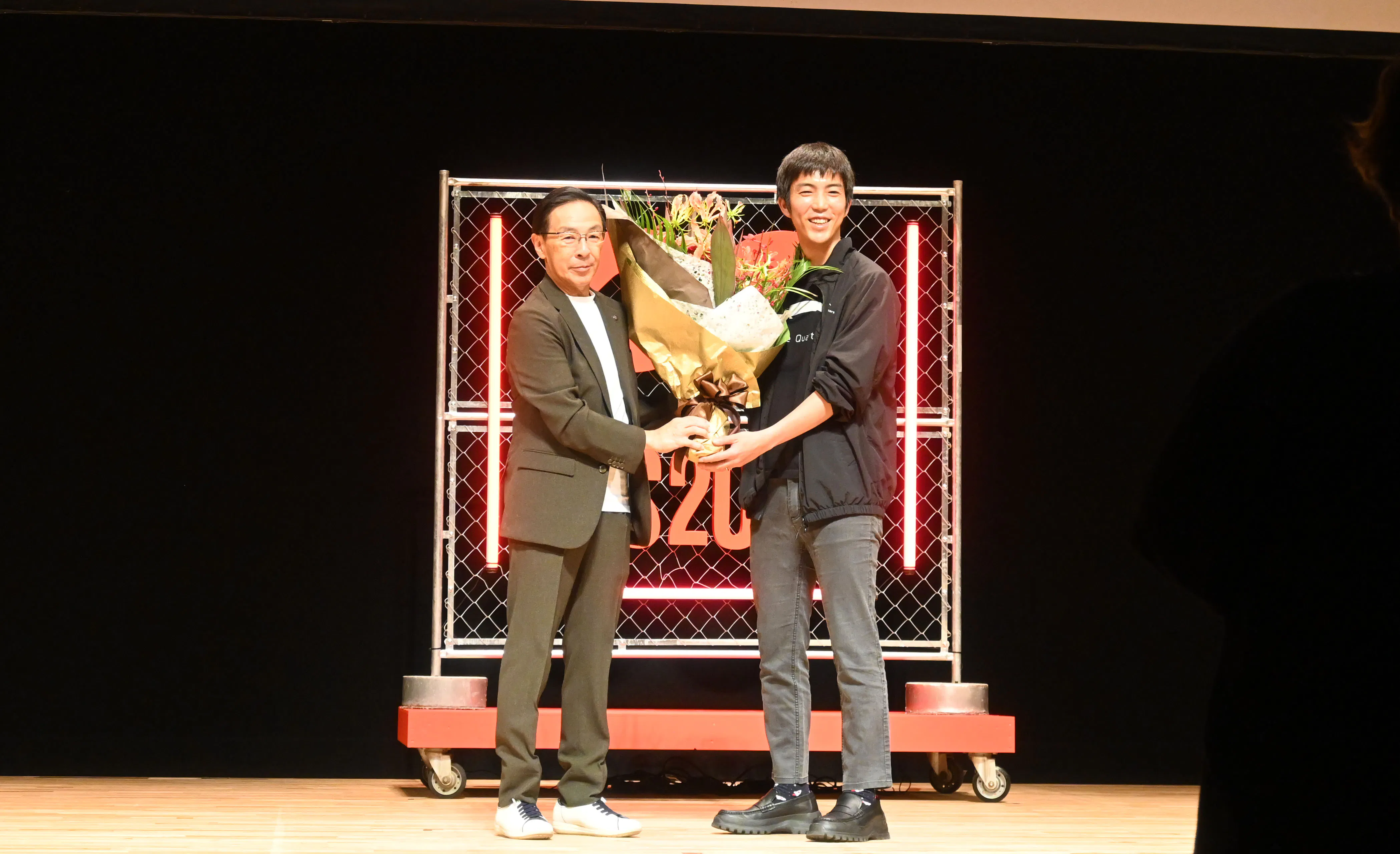 京都府の西脇知事から花束を受け取る共同創業者/COOの高橋 宗徳氏