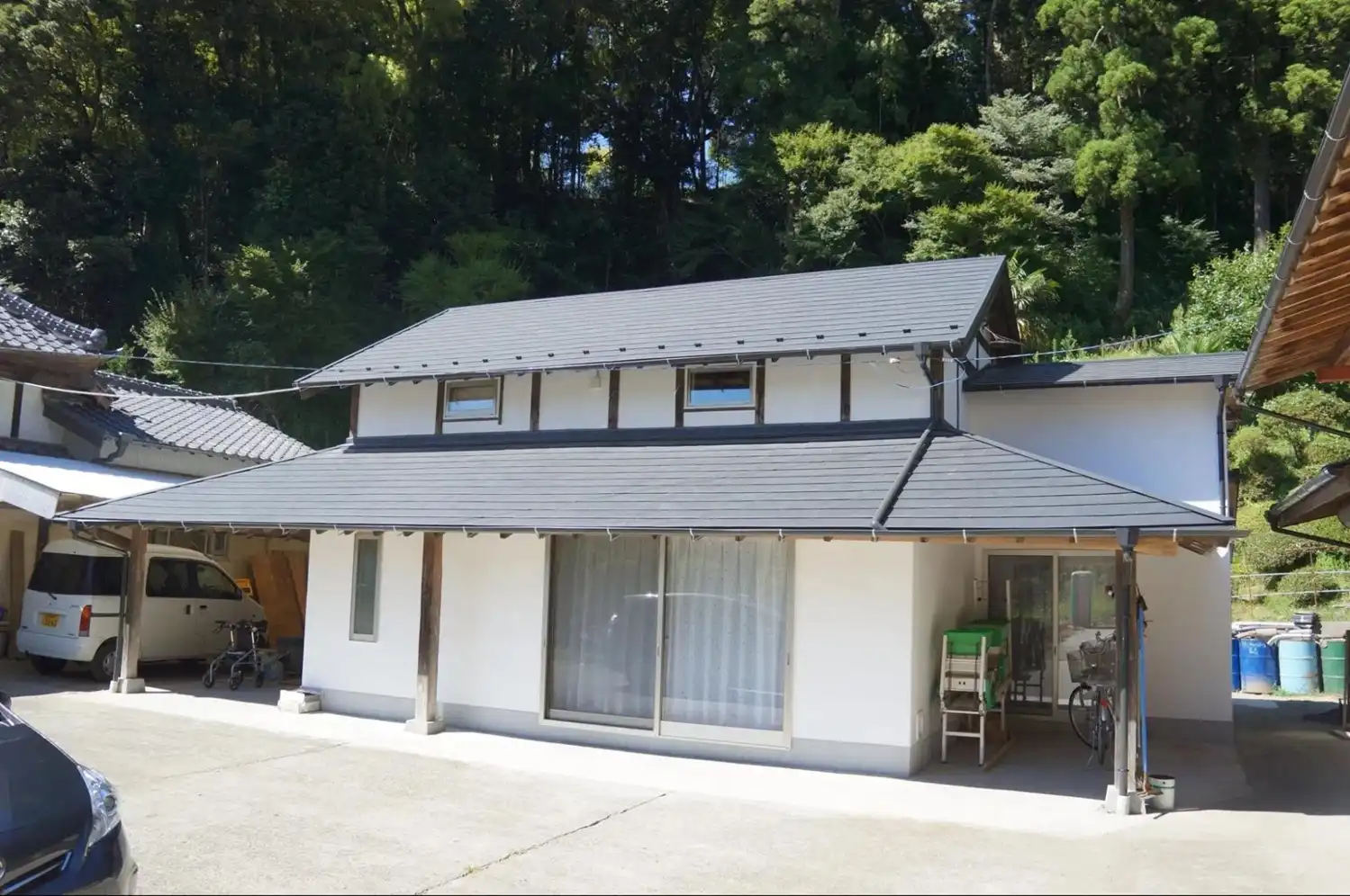 古い農家の納屋をリノベーションしたモダンな外観。愛着のある建物を活かし、白い漆喰の壁と新しい屋根で現代的なデザインに生まれ変わりました。