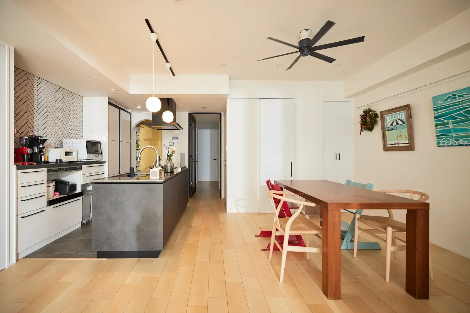 プロペラファンが映える高い天井と、北欧テイストを取り入れたナチュラルなLDK。回遊性の高い間取りの中心に重厚なアイランドキッチンを配置し、家族4人が快適に過ごせる空間に仕上げたempatiのリノベーション事例。