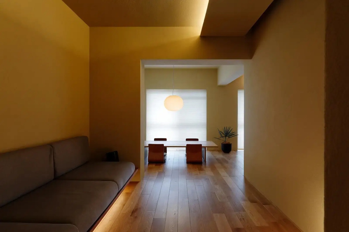 ひかり工務店による「洞窟」をコンセプトにしたリノベーション後のLDK。天井の低さを活かし、ジョリパット仕上げの壁と間接照明で包まれた静謐でミニマルな空間。