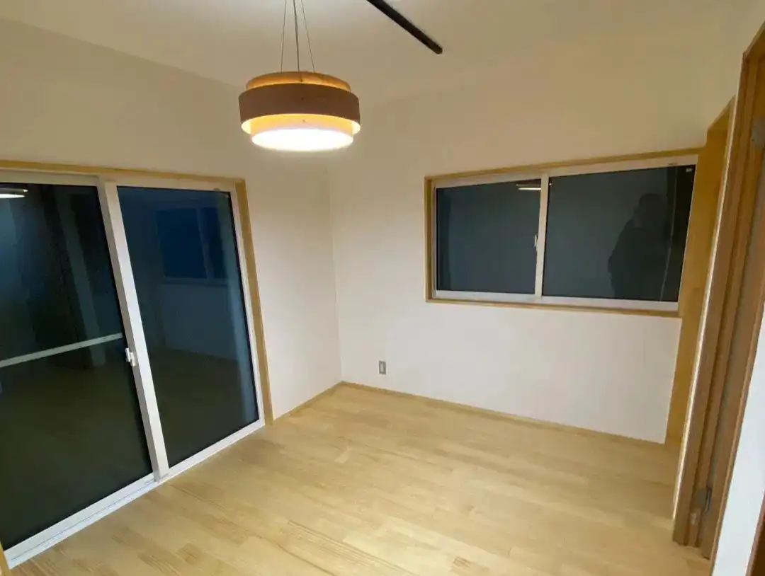 スケールメイクスによる築60年古民家リノベーション後の寝室。パインの無垢フローリングと漆喰の壁・天井で仕上げられた、自然素材の温かみを感じるシンプルな空間。