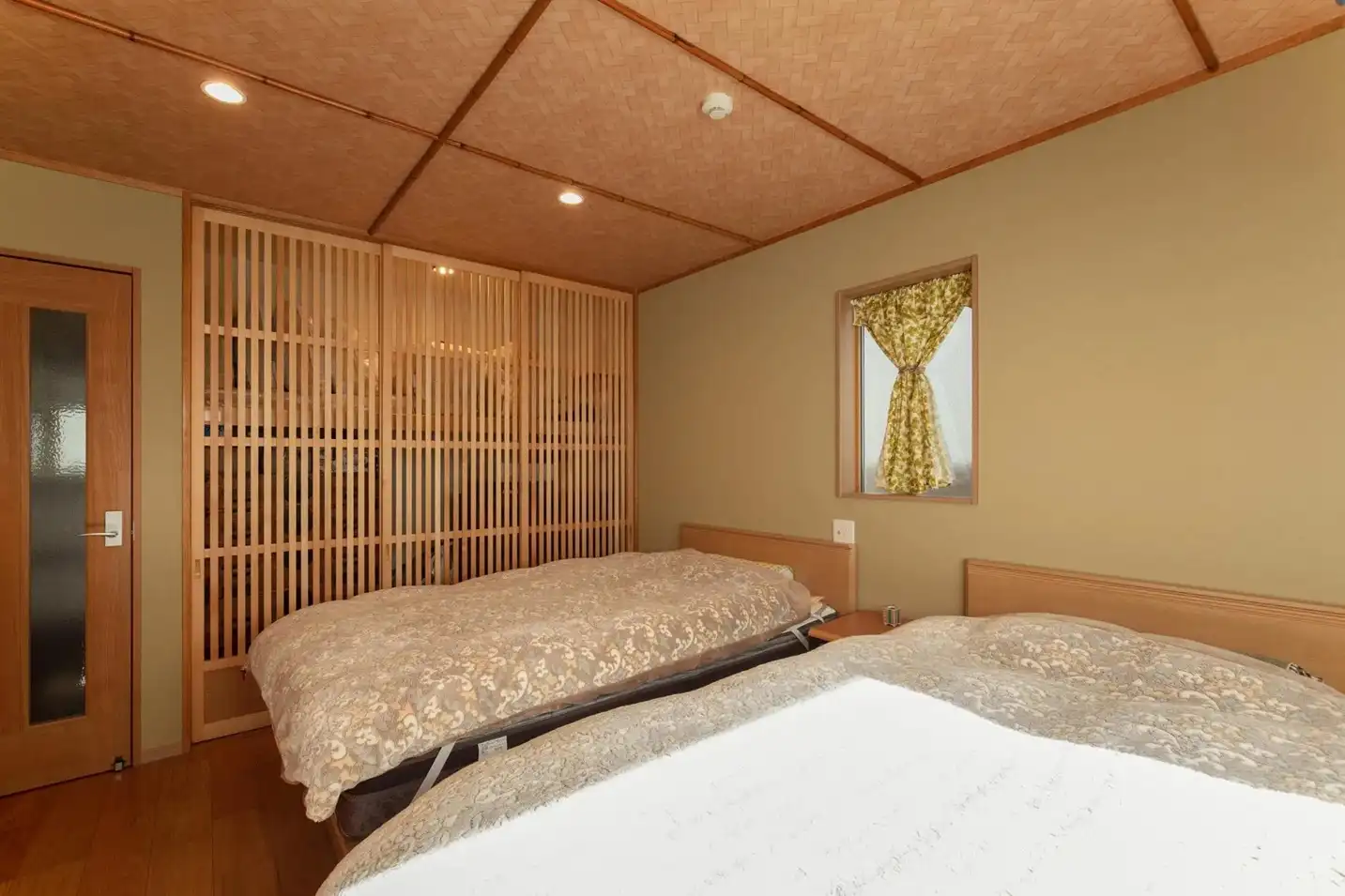 網代編み風の天井と、収納全面に使われた木製ルーバーの引き戸が特徴。旅館のような和の趣がある落ち着いた空間。