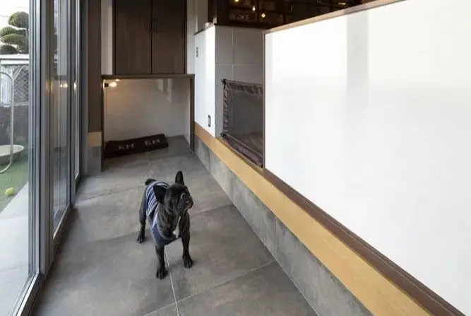 戸建てリノベーション後。ダイニング横に設けたグレータイル床の土間スペース。左手の窓から段差なく庭へ出られ、奥の棚下には照明付きの犬専用スペースを備える。愛犬と快適に暮らせる住まい。an cube(アン キューブ)のリノベーション事例。