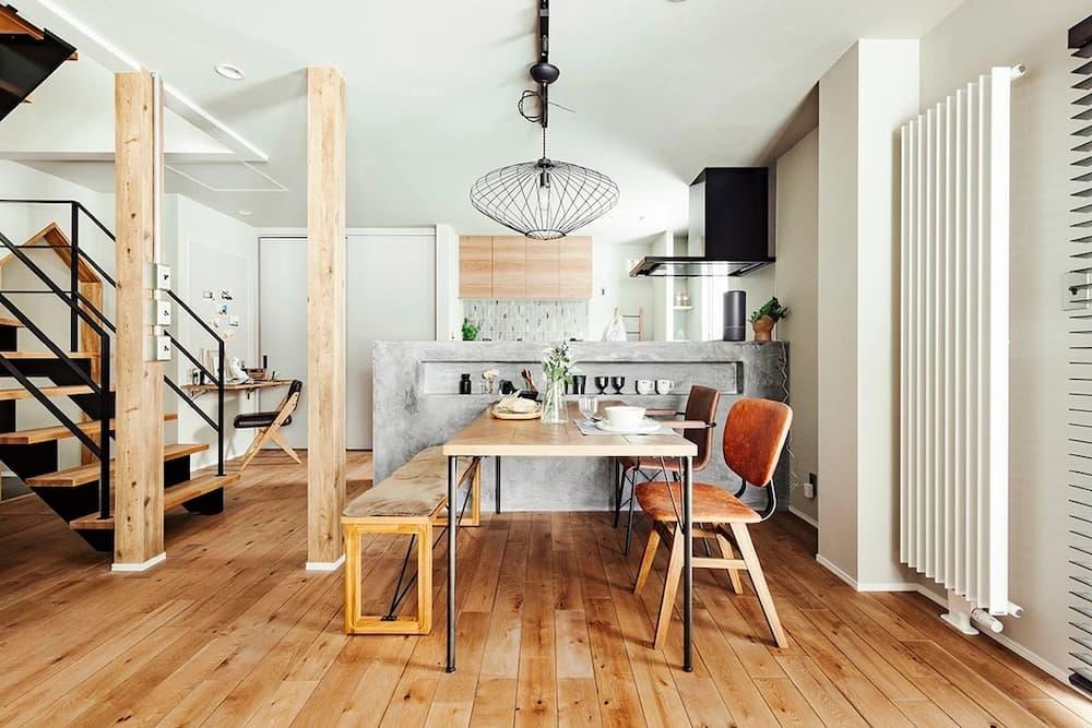 天井のデッキプレートを現しにしたインダストリアルなLDK。ギターや造作洗面台、壁面本棚が配置された大人のリノベーション事例