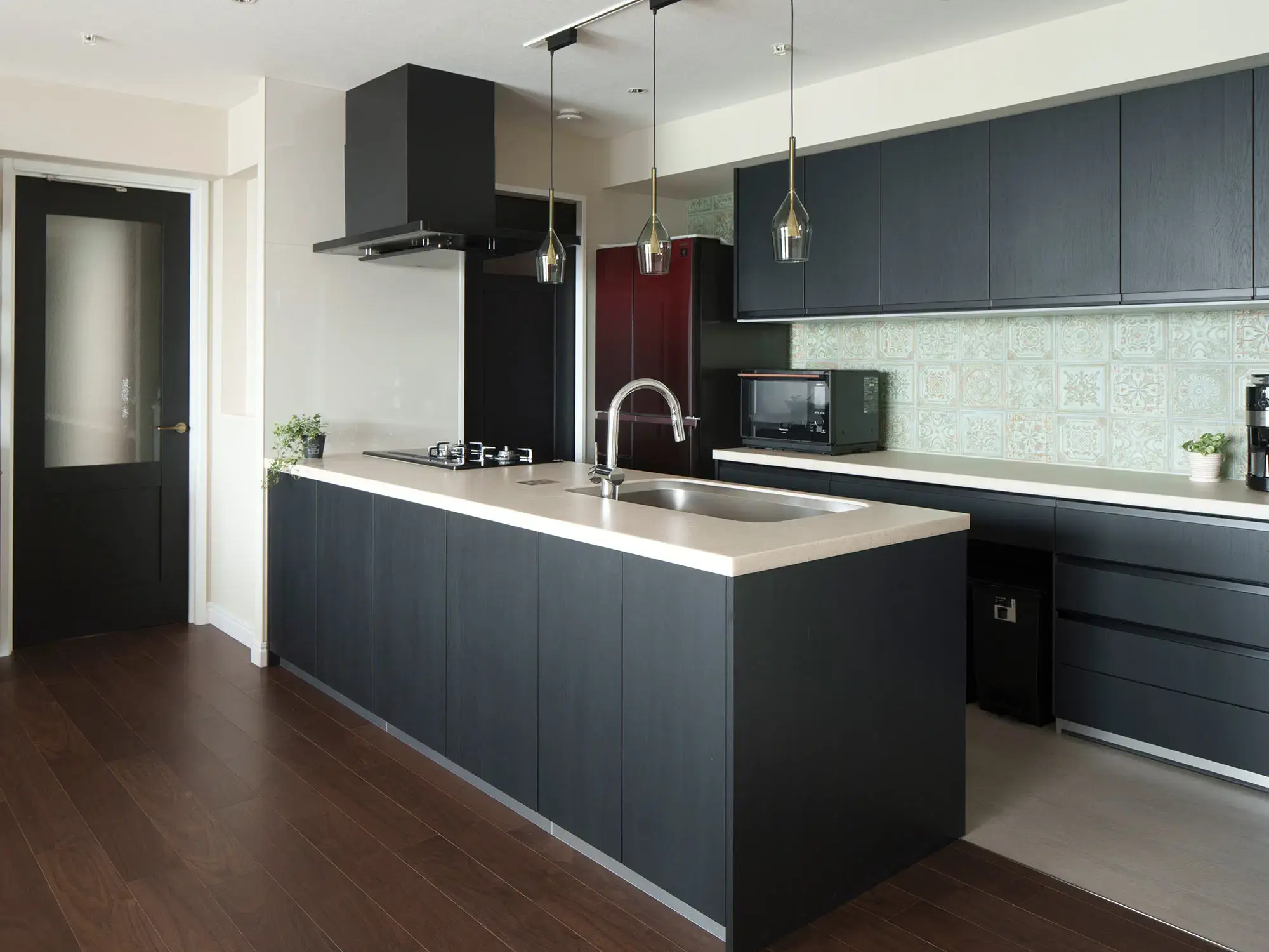 フローリングを基準に、クールなキャビネットとグリーンのリリーフタイルを組み合わせた、ホテルライクなキッチン。色彩バランスにこだわった気品あふれる空間。インテリックス空間設計。