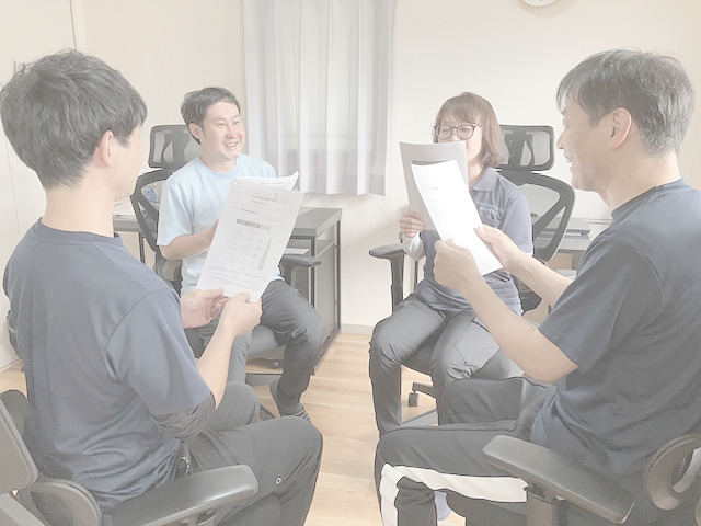 スタッフが書類を見ながら話し合っている写真