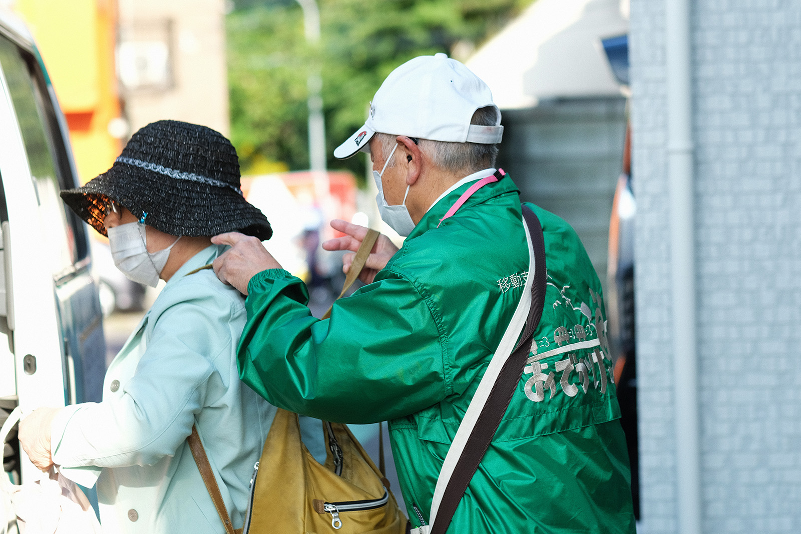 利用者の身支度を手伝う添乗員