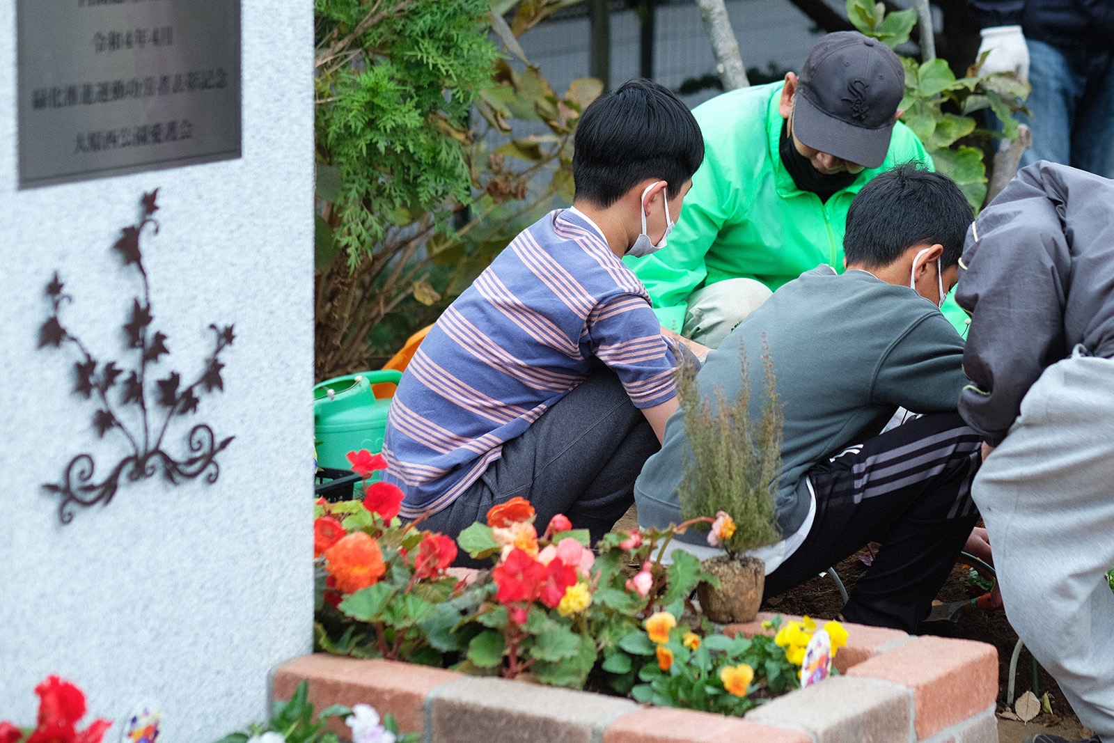 一緒にお花を植える、愛護会のみなさんと小学生たち