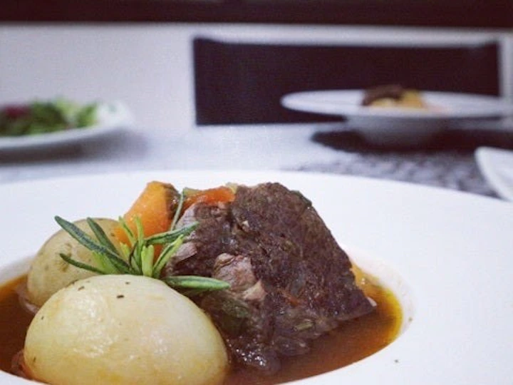 白いスープ皿に盛ったビーフシチュー。大きな牛肉と丸ごとのかぶ、にんじん、じゃがいも