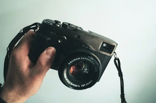 FUJIFILM(富士フイルム) X-E4とX-Pro3で迷う理由は、センサーや画像処理エンジンの世代が近いのに、カメラとしての作りが大きく違うからです。どちらも約2610万画素のAPS-C X-Trans CMOS 4センサーを採用したXシリーズの第4世代機で、同じレンズや近い設定で撮ると描写の傾向は似ています。ただし、2026年時点では購入時の流通状況も確認しておきたいところです。X-E4は公式製品ページで生産終了表記となっており、新品より中古や在庫品を探すケースが中心になります。また、X-Pro3も公式通販で新品販売価格を確認できないため、購入時は中古価格、外装状態、背面液晶の動作、ファインダーの見え方まで見て選ぶ必要があります。この記事では、スナップ、旅行、家族撮影、動画、雨天運用まで具体的な場面に落とし込み、X-E4とX-Pro3のどちらが合うかを比較します。最新AFや高画素センサー、ボディ内手ブレ補正を重視する場合は、後継機のX-E5も比較対象に入れてください。 この記事のサマリー X-E4とX-Pro3は同じ第4世代センサーを採用しており、画質の傾向は近い 軽さ、薄さ、背面モニターの使いやすさを重視するならX-E4が合いやすい OVF/EVFのハイブリッドファインダーや背面液晶を隠す設計に魅力を感じるならX-Pro3が向く 動画や自分撮りも撮るならX-E4、耐候性やデュアルスロットを重視するならX-Pro3を検討したい 2026年時点では、どちらも中古・在庫品の状態確認が大切になる FUJIFILM X-E4とX-Pro3はどちらを選ぶべきか FUJIFILM X-E4とX-Pro3は、どちらもFUJIFILMらしい色再現やフィルムシミュレーションを楽しめるカメラです。写りの方向性は近いため、選ぶときはファインダー、背面液晶、操作系、携帯性、耐候性を中心に見ると整理しやすくなります。 https://www.minnacamera.com/products/c1649 https://www.minnacamera.com/products/c1673 X-E4は背面モニター中心で軽く撮りたい人向け X-E4は、薄く軽いボディと180度チルト式モニターを備えたモデルです。旅行、散歩、家族写真、テーブルフォト、短い動画など、背面モニターで構図を確認しながら撮る場面に向いています。 【2026年版】FUJIFILM X-E4のレビュー比較まとめと手ぶれ補正対策 X-Pro3はファインダー中心で静止画を撮りたい人向け X-Pro3は、OVFとEVFを切り替えられるハイブリッドファインダーを備えたモデルです。さらに、トップカバーとベースプレートにチタン、内部フレームにマグネシウムを採用し、防塵防滴耐低温やデュアルスロットにも対応しています。背面モニターを頻繁に見る撮り方より、ファインダーをのぞいて静止画を撮るスタイルに合うカメラです。 【2026年版】Fujifilm X-Pro3のレビュー比較まとめ。ストリート撮影向け 迷ったら「背面モニター中心か、ファインダー中心か」で選ぶ 迷ったときは、撮影中に背面モニターを見ることが多いか、ファインダーをのぞくことが多いかを基準にすると選びやすくなります。背面モニター中心で軽く持ち歩きたいならX-E4、ファインダー中心で撮影し、天候変化や記録管理にも備えたいならX-Pro3を検討するとよいでしょう。 FUJIFILM X-E4 vs X-Pro3の比較早見表 まずは、X-E4とX-Pro3の違いを一覧で整理します。画質の土台は近いものの、ファインダー、背面モニター、記録メディア、耐候性には明確な違いがあります。 項目 FUJIFILM X-E4 FUJIFILM X-Pro3 比較ポイント 画質のベース 約2610万画素 X-Trans CMOS 4 約2610万画素 X-Trans CMOS 4 写りの傾向は近く、レンズやフィルムシミュレーションで印象が変わる ファインダー 0.39型 約236万ドットEVF OVF/EVF切替式ハイブリッドファインダー、EVF 約369万ドット ファインダーをのぞいて撮る時間が長いならX-Pro3 背面モニター 3.0型 約162万ドット、180度チルト式タッチパネル 3.0型 約162万ドット、下開きチルト式タッチパネル(収納時は背面側を隠す構造) 背面で構図を作るならX-E4、ファインダー中心ならX-Pro3 携帯性 約364g 約497g 散歩や旅行で常に持ち歩くならX-E4が軽い 記録メディア SD系シングルスロット、UHS-I対応 SD系デュアルスロット、UHS-I/UHS-II対応 2枚のSDカードで記録を管理したいならX-Pro3 耐候性 防塵防滴の記載なし 防塵防滴耐低温(防水ではない) 雨天や寒冷地で使うならX-Pro3を検討したい 価格 公式通販で新品販売の掲載なし 公式通販で新品販売の掲載なし 2026年時点では中古・在庫品の状態確認が重要 おすすめの人 軽さ、日常、旅行、動画も重視する人 OVF体験、耐候性、記録の保険を重視する人 撮影スタイルに合わせて選ぶ ※価格は、2026年7月6日時点の公式通販サイトで確認できた販売価格または掲載状況です。 主要スペック比較|同じ世代でも使い勝手は大きく違う Via: Digital Camera World(X-E4) Via: PetaPixel(X-Pro3) ここでは、公式仕様をもとに撮影スタイルに関わる項目を整理します。X-E4とX-Pro3はセンサーや画像処理エンジンが共通する一方で、ファインダー方式、背面モニター、カードスロット、ボディサイズ、耐候性に違いがあります。 数値を見るときは、単純な大小だけでなく、自分の撮影でどの項目をよく使うかを基準にすると判断しやすくなります。背面モニターをよく使う人はモニター構造、イベント撮影が多い人はスロット数、雨の日や寒冷地で使う人は耐候性を確認しましょう。 主要スペック比較表 以下の表では、X-E4とX-Pro3の共通点と違いを整理しています。画質に関わる基本性能だけでなく、ファインダー、モニター、記録まわり、サイズの差もあわせて確認しましょう。 項目 FUJIFILM X-E4 FUJIFILM X-Pro3 センサー APS-C X-Trans CMOS 4 APS-C X-Trans CMOS 4 有効画素数 約2610万画素 約2610万画素 画像処理エンジン X-Processor 4 X-Processor 4 ファインダー 0.39型有機EL EVF 約236万ドット ハイブリッドビューファインダー、EVF 約369万ドット 背面モニター 3.0型 約162万ドット、チルト式タッチパネル 3.0型 約162万ドット、180度チルト式タッチパネル(収納時は背面側を隠す構造) サブモニター なし 1.28型カラーメモリ液晶 メモリーカード SD/SDHC/SDXC、UHS-I対応 SD/SDHC/SDXC、UHS-I/UHS-II対応 スロット数 1スロット 2スロット 動画 DCI4K/4K 29.97pまで、FHDハイスピード240pまで DCI4K/4K 29.97pまで、FHDハイスピード120pまで 防塵防滴耐低温 記載なし 対応 サイズ(幅×高さ×奥行) 121.3×72.9×32.7mm 140.5×82.8×46.1mm(最薄部34.8mm) 質量(撮影時) 約364g 約497g 価格 公式通販で新品販売の掲載なし 公式通販で新品販売の掲載なし ※価格は、2026年7月6日時点の公式通販サイトで確認できた販売価格または掲載状況です。 サイズと重量で見る違い X-E4は、幅121.3mm、高さ72.9mm、奥行32.7mm、撮影時約364gの薄型軽量ボディです。XF27mmF2.8 R WRのようなパンケーキレンズや、XF35mmF2 R WRのような小型単焦点と組み合わせると、小さなバッグにも入れやすくなります。散歩や旅行でカメラを常に持ち歩きたい人に向いたサイズ感です。 X-Pro3は、幅140.5mm、高さ82.8mm、奥行46.1mm、撮影時約497gのボディです。X-E4より大きく重いものの、ファインダーまわりや外装、カードスロット、耐候性に余裕があります。また、XF23mmF1.4 R LM WRやXF33mmF1.4 R LM WRのような少し大きめの単焦点レンズとも組み合わせやすいでしょう。 使ってわかるモニターまわりの違い X-E4は、背面モニターを開いて撮る機会が多い人に向いています。腰の高さで構えたり、テーブル上の料理を撮ったり、旅行先で自分を入れて記録したりする場面では、180度チルト式モニターを活用しやすい構造です。 X-Pro3は、背面液晶を閉じたままファインダーをのぞいて撮る時間が長くなるカメラです。撮影後の確認を少なくし、被写体を見ながら構図を作りたい人には合います。ただし、背面モニターで頻繁に構図や再生画像を確認する人は、液晶を開く動作が手間に感じるかもしれません。 画質・AFの比較|写真の土台は近く、差は撮り方に出る Via: PetaPixel 作例(X-E4) Via: Digital Camera World 作例(X-Pro3) FUJIFILM X-E4とX-Pro3は、どちらも約2610万画素のAPS-C X-Trans CMOS 4センサーを採用しています。同じレンズ、近い露出、同じフィルムシミュレーションで撮るなら、写真の傾向はかなり近くなります。 そのため、この2機種は「どちらが高画質か」よりも、どちらの構え方や操作テンポが自分に合うかを見て選ぶとよいでしょう。 画質はレンズとフィルムシミュレーションで印象が変わる X-E4とX-Pro3の写真は、ボディよりもレンズ選びやフィルムシミュレーションで印象が変わります。たとえば同じ標準域でも、XF27mmF2.8 R WRなら薄く軽いスナップ向けの組み合わせになり、XF33mmF1.4 R LM WRなら背景を大きくぼかした描写を狙えます。 https://www.minnacamera.com/products/l3887 https://www.minnacamera.com/products/l3889 また、クラシックネガでコントラストを強めに見せるのか、PROVIAで自然に残すのか、ACROSでモノクロに仕上げるのかによって、同じボディでも写真の雰囲気は変わります。 AFは顔・瞳検出まで対応し、最新の被写体検出AFは非対応 X-E4とX-Pro3は、どちらも像面位相差AFを含むインテリジェントハイブリッドAFを採用しています。顔・瞳検出にも対応しているため、日常スナップ、旅行、家族写真、静かなポートレートでは扱いやすいでしょう。 ただし、動物や乗り物などを自動で判別する最新世代の被写体検出AFは搭載していません。さらに、体感の差はAF性能そのものより操作方法に出ます。X-E4はボタンを減らしたミニマルな操作系なので、タッチ操作やメニュー操作に慣れている人向けです。X-Pro3は、ファインダーをのぞきながらジョイスティックや物理操作でAFエリアを動かしたい人に向いています。 ファインダーと背面モニターの比較|2機種で大きく違う部分 Via: Digital Camera World(X-E4) Via: DP Review(X-Pro3) FUJIFILM X-E4とX-Pro3を比べるうえで、特に差が出るのがファインダーと背面モニターです。X-E4はEVFと180度チルト式モニターで、背面画面を見ながら構図を作りやすいモデルです。対してX-Pro3は、OVF/EVFを切り替えられるハイブリッドファインダーと、収納時に背面側を隠すモニター構造を採用しています。 X-E4は背面モニターを使った撮影に向く X-E4はEVFのみのシンプルな構成です。背面モニターはチルト式で、前方に向けることもできます。腰位置スナップ、ローアングル、テーブルフォト、旅行先での自分撮り、家族集合写真など、背面モニターを見ながら撮る場面で扱いやすいカメラです。 ただし、EVFは0.39型 約236万ドットで、X-Pro3のEVFより小さめです。眼鏡をかけている人や、ファインダーの見やすさを重視する人は、購入前に実機で見え方を確認しましょう。 X-Pro3はハイブリッドファインダーで構図の作り方が変わる X-Pro3は、OVFとEVFを切り替えられるハイブリッドファインダーを採用しています。OVFでは撮影範囲の外側も見えるため、街の流れや光の変化を見ながら構図を作れます。EVFに切り替えれば、露出や色の反映を確認しながら撮影可能です。 また、背面液晶は収納時に背面側を隠す構造です。閉じた状態ではサブモニターでフィルムシミュレーションなどを確認でき、必要なときだけ背面液晶を開きます。背面画面を常に見る撮り方より、ファインダーをのぞきながら露出や構図を整えたい人に合います。 撮影シーン別の比較表 以下の表では、撮影シーンごとにX-E4とX-Pro3の使いやすさを整理しています。背面モニターを使う頻度と、ファインダーをのぞく時間の長さを基準に見てください。 シーン FUJIFILM X-E4 FUJIFILM X-Pro3 比較ポイント 腰位置スナップ チルトモニターで構図を確認しやすい 下開きモニターで対応できる 背面確認のしやすさはX-E4 街歩きスナップ EVFと背面モニターを使い分けやすい OVFで撮影範囲の外側も見ながら撮れる ファインダーを重視するならX-Pro3 家族集合写真 前方に向けられるモニターが使いやすい 自分撮りには向きにくい 家族用途はX-E4が扱いやすい 撮影後の確認 背面モニターですぐ確認できる 液晶を開く動作が入る 確認頻度が高い人はX-E4 操作性・UIの比較|シンプルなX-E4、ファインダー中心のX-Pro3 Via: Digital Camera World(X-E4) Via: DP Review(X-Pro3) 操作性を見るときは、撮影中に変えたい項目の多さを基準にします。露出補正や絞り(F値)、フィルムシミュレーションを中心に使うならX-E4でも扱いやすく、ファインダーをのぞいたまま設定を追い込みたいならX-Pro3が候補になります。 X-E4は少ないボタンで迷わず撮りたい人向け X-E4は、ボタン類を減らして薄く軽いボディにまとめたモデルです。普段から露出補正、絞り(F値)、フィルムシミュレーションを中心に使う人なら、操作が複雑になりすぎず扱いやすいでしょう。 また、背面のフォーカスレバーでAFエリアを動かせるため、すべてをタッチ操作やメニュー操作に頼るわけではありません。ただし、AFモード、顔・瞳検出、測光、カスタム設定などを撮影中に細かく切り替える人は、ボタンの少なさを物足りなく感じる可能性があります。 X-Pro3はファインダーをのぞいたまま操作したい人向け X-Pro3は、OVF/EVFの切り替え、閉じた状態で設定を確認できるサブモニター、物理ダイヤルを使って撮るモデルです。背面モニターを頻繁に見ず、ファインダーをのぞきながら露出や構図を整えたい人に合います。 ただし、背面液晶でメニュー操作や再生確認を頻繁に行う人は、液晶を開く動作が毎回入ります。そのため、背面モニター中心でテンポよく撮りたい人は、X-E4のほうが使いやすく感じるでしょう。 操作スタイル別の比較表 以下の表では、撮影中の操作量や確認方法ごとに、X-E4とX-Pro3の向き不向きを整理しています。自分がよく変える設定や、撮影後の確認頻度を基準に見てください。 操作の方向性 FUJIFILM X-E4 FUJIFILM X-Pro3 比較ポイント 撮影中に設定をあまり変えない 少ないボタンで迷いにくい 物理操作の選択肢が多い シンプルに撮るならX-E4 AFエリアを動かしたい フォーカスレバーで操作できる ファインダーをのぞいたまま操作しやすい どちらも物理操作に対応 撮影中に設定をよく変える ボタン数の少なさが気になる場合がある ダイヤルやレバーで変更しやすい 操作量が多い人はX-Pro3 背面で再生確認をよくする 背面モニターですぐ確認できる 液晶を開く動作が入る 確認頻度が高い人はX-E4 ファインダーをのぞいて撮り続けたい EVFでシンプルに撮れる OVF/EVFを使い分けられる ファインダー重視ならX-Pro3 携帯性・レンズバランスの比較|約133gの差が持ち歩き方を変える Via: Photography Blog(X-E4) Via: PetaPixel(X-Pro3) FUJIFILM X-E4とX-Pro3の重量差は約133gです。数字だけでは小さく見えても、レンズを付けて半日歩く、旅行で一日首から下げる、子どもと公園を歩くといった場面では体感に差が出ます。 X-E4は小型単焦点と組むとバッグに入れやすい X-E4は薄く軽いため、小型単焦点レンズと組み合わせると小さなバッグにも入れやすいモデルです。XF27mmF2.8 R WRやXF35mmF2 R WRのような小型レンズなら、旅行や街歩きにもなじみます。 また、大きなカメラを持つほどではない外出でも、X-E4なら荷物に加えやすいでしょう。カメラを持っていく回数を増やしたい人に向いたサイズ感です。 ただし、大口径単焦点や重めのズームを付けると、レンズ側に重さが寄りやすくなります。長時間の手持ちでは、追加グリップやサムレストの併用も検討しましょう。 X-Pro3は中型レンズやWRズームと合わせやすい X-Pro3はX-E4より大きく重いぶん、少し大きめの単焦点やWRズームを付けても構えやすいモデルです。グリップ感やファインダーの見やすさを重視する人なら、サイズ差を受け入れやすいでしょう。 XF23mmF1.4 R LM WR、XF33mmF1.4 R LM WR、XF16-80mmF4 R OIS WRのようなレンズをよく使う人は、ボディとのバランスも確認しておきたいところです。反対に、毎日の散歩用カメラとして考えるなら、X-E4の軽さが扱いやすさにつながります。 携帯性とレンズ相性の比較表 以下の表では、ボディ重量とレンズ装着時の扱いやすさを比較します。小型単焦点を中心に使うのか、少し大きめの単焦点やWRズームまで使うのかを基準に見てください。 観点 FUJIFILM X-E4 FUJIFILM X-Pro3 比較ポイント ボディ重量 約364g 約497g 長時間持ち歩くならX-E4が軽い おすすめレンズ傾向 小型単焦点、パンケーキ 小型から中型単焦点、WRズーム よく使うレンズのサイズで選びたい 日常での持ち出し 小さなバッグにも入れやすい 撮影目的の外出に合う 散歩や旅行中心ならX-E4 レンズバランス 大きいレンズでは前寄りになりやすい 中型レンズとも合わせやすい ボディ単体ではなくレンズ込みで考える 耐候性・記録まわりの比較|X-E4は日常向き、X-Pro3は天候変化にも備えやすい Via: Photography Blog(X-E4) Via: DP Review(X-Pro3) 記録メディアと耐候性を見ると、X-E4は日常撮影向けのシンプルな構成です。対してX-Pro3は、2スロット構成と防塵防滴耐低温により、旅先やイベント撮影でも記録管理と天候変化に対応しやすい仕様になっています。 X-E4はシングルスロットで、防塵防滴の記載はない X-E4は、SDカードのシングルスロットでUHS-I対応です。日常スナップ、旅行、家族写真では扱いやすい構成ですが、2枚のSDカードを使った記録管理には対応していません。 また、公式仕様上は防塵防滴ボディとしての記載がありません。小雨や砂埃のある環境で長く使う場合は、レインカバーやカメラバッグで保護しながら使いましょう。 X-Pro3はデュアルスロットと防塵防滴耐低温に対応 X-Pro3は、SDカードのデュアルスロットを備え、UHS-I/UHS-IIに対応しています。RAWとJPEGの振り分け、順次記録、バックアップ記録などを使いたい人に向いた構成です。 さらに、防塵防滴耐低温に対応しているため、寒冷地や天候が変わりやすい場所でも使いやすいモデルです。ただし、防水カメラではありません。雨天で使う場合は、WRレンズとの組み合わせやレインカバーを用意しましょう。豪雨や水しぶきの強い場所での使用は避けてください。 撮影シーン別の比較表 以下の表では、撮影シーンごとに記録メディアと耐候性の違いを整理しています。日常撮影が中心か、天候変化やデータ管理まで考えたいかを基準に見てください。 シーン FUJIFILM X-E4 FUJIFILM X-Pro3 比較ポイント 家族イベント 1枚のSDカードに記録 2スロットで記録管理しやすい 記録の管理方法まで考えるならX-Pro3 旅行 軽く持ち歩きやすい 天候変化に備えやすい 荷物の軽さ重視ならX-E4、天候対応も見るならX-Pro3 小雨や寒冷地 保護用品を併用したい 防塵防滴耐低温に対応 X-Pro3も防水ではないため、WRレンズやレインカバーを組み合わせたい 日常スナップ 軽く扱いやすい 記録や耐候性の選択肢がある 気軽に撮るならX-E4、撮影環境の幅を見るならX-Pro3 動画の比較|自分撮りや日常動画ならX-E4が扱いやすい Via: Digital Camera World 作例(X-E4) Via: DP Review 作例(X-Pro3) FUJIFILM X-E4とX-Pro3は、どちらもDCI4K/4K 29.97pまでの動画撮影に対応しています。ただし、動画では記録解像度だけでなく、背面モニターの向きや構図確認のしやすさも重要です。自分を画面に入れて撮る機会があるなら、前方に向けられるモニターを備えたX-E4のほうが扱いやすいでしょう。 X-E4は自分撮りや旅行動画に使いやすい X-E4は、DCI4K/4K 29.97pまでの動画撮影に対応し、Full HDではハイスピード動画240pまで記録できます。背面モニターを前方に向けられるため、自分を入れた動画や旅行中の短い記録、家族での集合動画を撮りやすい構造です。 ただし、ボディ内手ブレ補正はありません。歩きながら撮る場面が多い場合は、OIS付きレンズ、軽いグリップ、ジンバルなども検討しましょう。構図を自分で見ながら撮れる点は、X-Pro3との大きな違いです。 X-Pro3は静止画中心で、動画は短い記録向き X-Pro3もDCI4K/4K 29.97pまでの動画撮影に対応し、Full HDではハイスピード動画120pまで記録できます。ただし、背面モニターは収納時に背面側を隠す構造で、自分撮りには向きません。 動画を少し撮る程度ならX-Pro3でも対応できます。反対に、Vlogや自撮り動画をよく撮る人は、構図確認のしやすさを考えるとX-E4のほうが選びやすいでしょう。 動画用途の比較表 以下の表では、動画の目的ごとにX-E4とX-Pro3の違いを整理しています。動画をメインに使うのか、静止画の合間に短く残すのかを基準に見てください。 動画の目的 FUJIFILM X-E4 FUJIFILM X-Pro3 比較ポイント 自分撮り/Vlog 前方に向けられるモニターで構図を確認しやすい 自分撮りには向きにくい 動画も重視するならX-E4 旅行の記録動画 軽く持ち歩きやすく、自分も画面に入れやすい 静止画の合間に短く撮る使い方向け 撮影頻度で選びたい スローモーション素材 Full HD 240pまで Full HD 120pまで ハイスピード動画はX-E4のほうが高いフレームレートに対応 静止画のついでの短い動画 問題なく使える 問題なく使える 動画の頻度が少ないならどちらでも選べる 用途別の選び方|スナップ・旅行・動画・雨天で考える Via: Digital Camera World 作例(X-E4) Via: DP Review 作例(X-Pro3) FUJIFILM X-E4とX-Pro3は、どちらが上というより、撮り方や購入時に重視するポイントで選ぶカメラです。ここでは日常撮影、ファインダー中心の撮影、天候変化への対応、中古購入時の見方に分けて整理します。 用途・重視ポイント別の比較表 以下の表では、撮影スタイルや購入時の判断軸ごとにおすすめしやすい機種をまとめています。自分がよく撮る場面と、購入時に確認したい条件を合わせて見てください。 重視するポイント おすすめの機材 理由 日常・旅行・家族写真 FUJIFILM X-E4 約364gの軽量ボディと前方に向けられる背面モニターにより、街歩き、集合写真、自分撮りまで対応しやすい ストリート/ドキュメンタリー FUJIFILM X-Pro3 OVF/EVFの切り替えと背面液晶を閉じる設計が、ファインダー中心の撮影に合う 雨天・寒冷地・イベント FUJIFILM X-Pro3 防塵防滴耐低温とデュアルスロットにより、天候変化や記録管理まで見て選べる 中古・在庫品の価格で選ぶ 両方を比較 2026年時点では個体状態と価格差が大きいため、外装・液晶・ファインダー・カードスロットを確認したい 2026年時点での購入前チェック FUJIFILM X-E4とX-Pro3は、どちらも発売から時間が経っているモデルです。新品価格だけで比較するより、中古品や在庫品の状態を見て選ぶほうが重要になります。 X-E4は背面モニターや端子まわりを確認したい X-E4を探す場合は、背面モニターの開閉、USB-C端子、シャッターボタン、ダイヤル、ボディ角の傷を確認したいところです。グリップが浅いモデルなので、サムレストや追加グリップの有無も使い勝手に関わります。 X-Pro3はファインダーと背面液晶の動作を見たい X-Pro3を探す場合は、ハイブリッドファインダーの見え方、背面液晶の開閉、サブモニター表示、SDカードスロット、外装の傷、ファインダー内のゴミを確認しましょう。特に背面液晶の構造はX-Pro3の特徴なので、開閉に違和感がない個体を選びたいところです。 最新機能を重視するならX-E5も候補に入る また、最新機能を重視するならX-E5も候補です。X-E5は約4020万画素のX-Trans CMOS 5 HRセンサー、X-Processor 5、5軸ボディ内手ブレ補正を備えた後継機です。X-E4の小型軽量な方向性が好きで、高画素センサーや新しいAFまわりの性能を求めるなら、X-E5との比較もおすすめできます。 FUJIFILM X-E4とX-Pro3の比較まとめ FUJIFILM(富士フイルム) X-E4とX-Pro3は、同じ第4世代センサーを採用した近い世代のカメラですが、撮影体験は大きく異なります。X-E4は、軽さ、薄さ、180度チルト式モニターを重視する人向けのモデルです。日常スナップ、旅行、家族写真、短い動画、自分撮りまで一台で使いたい人に合います。対してX-Pro3は、ハイブリッドファインダー、防塵防滴耐低温、デュアルスロット、背面液晶を隠す設計に魅力を感じる人向けです。ファインダーをのぞいて撮る時間を大切にしたい人や、静止画中心で撮影に向き合いたい人なら、X-Pro3らしい撮影感を楽しめるでしょう。背面モニター中心で軽く撮るならX-E4、ファインダー中心で写真体験を楽しむならX-Pro3。2026年時点では、どちらも中古・在庫品が中心になるため、スペックだけでなく個体状態と価格を見て選びましょう。