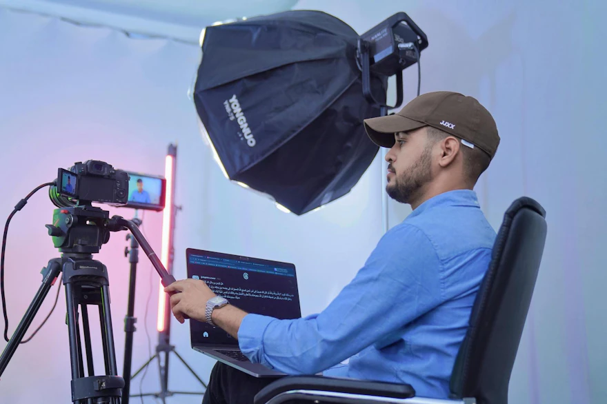 A photographer works in a studio with advanced camera and lighting equipment, showcasing professional filming.