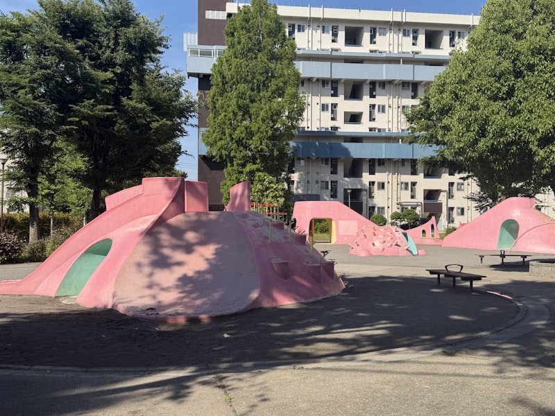 公園の遊具。ピンク色の奇妙な形のアスレチックがある。