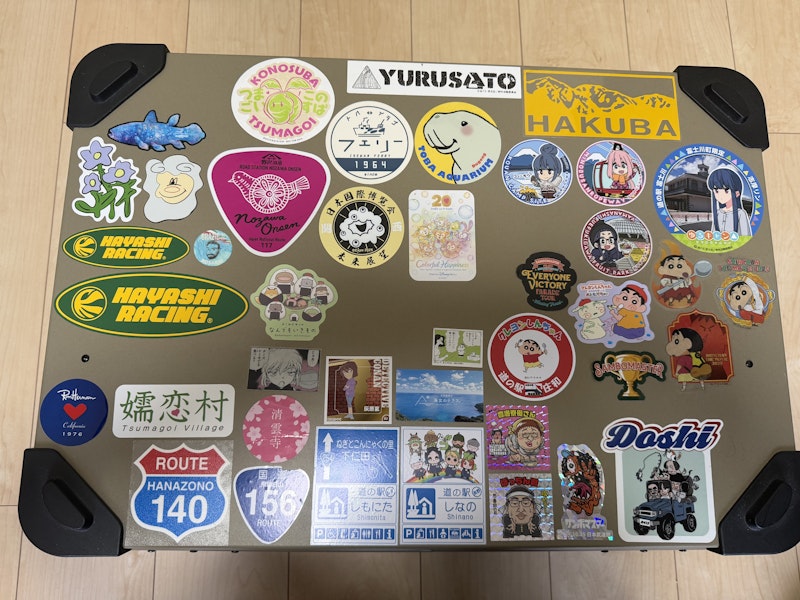 アルミコンテナボックスの一面がシールで埋め尽くされている