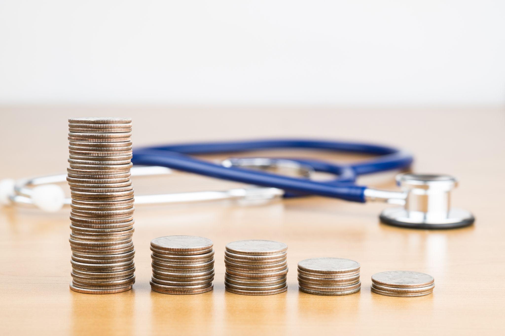 積み上がった硬貨と聴診器、補助金利用の可能性のイメージ