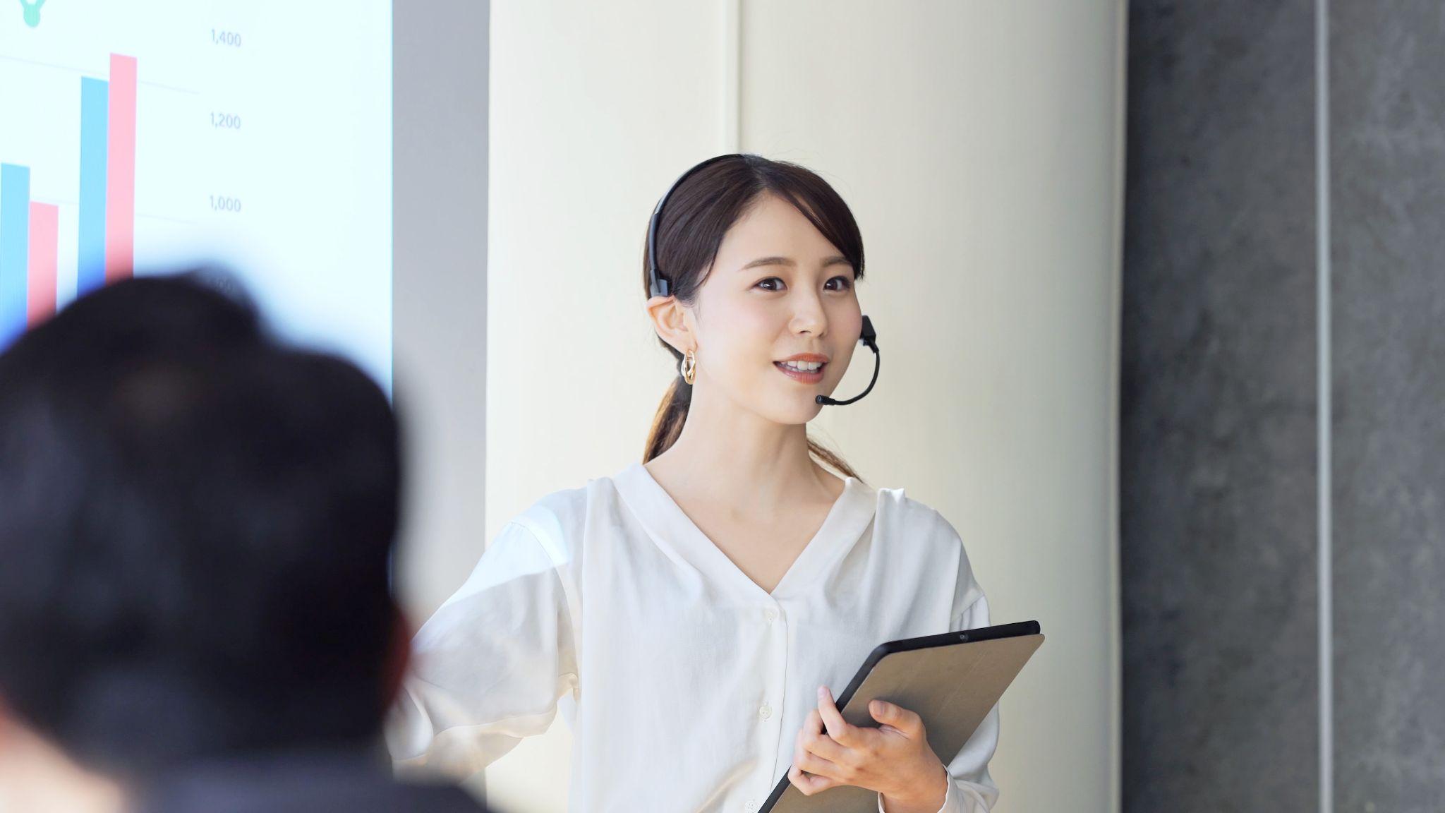 展示会でタブレットを持って説明している様子