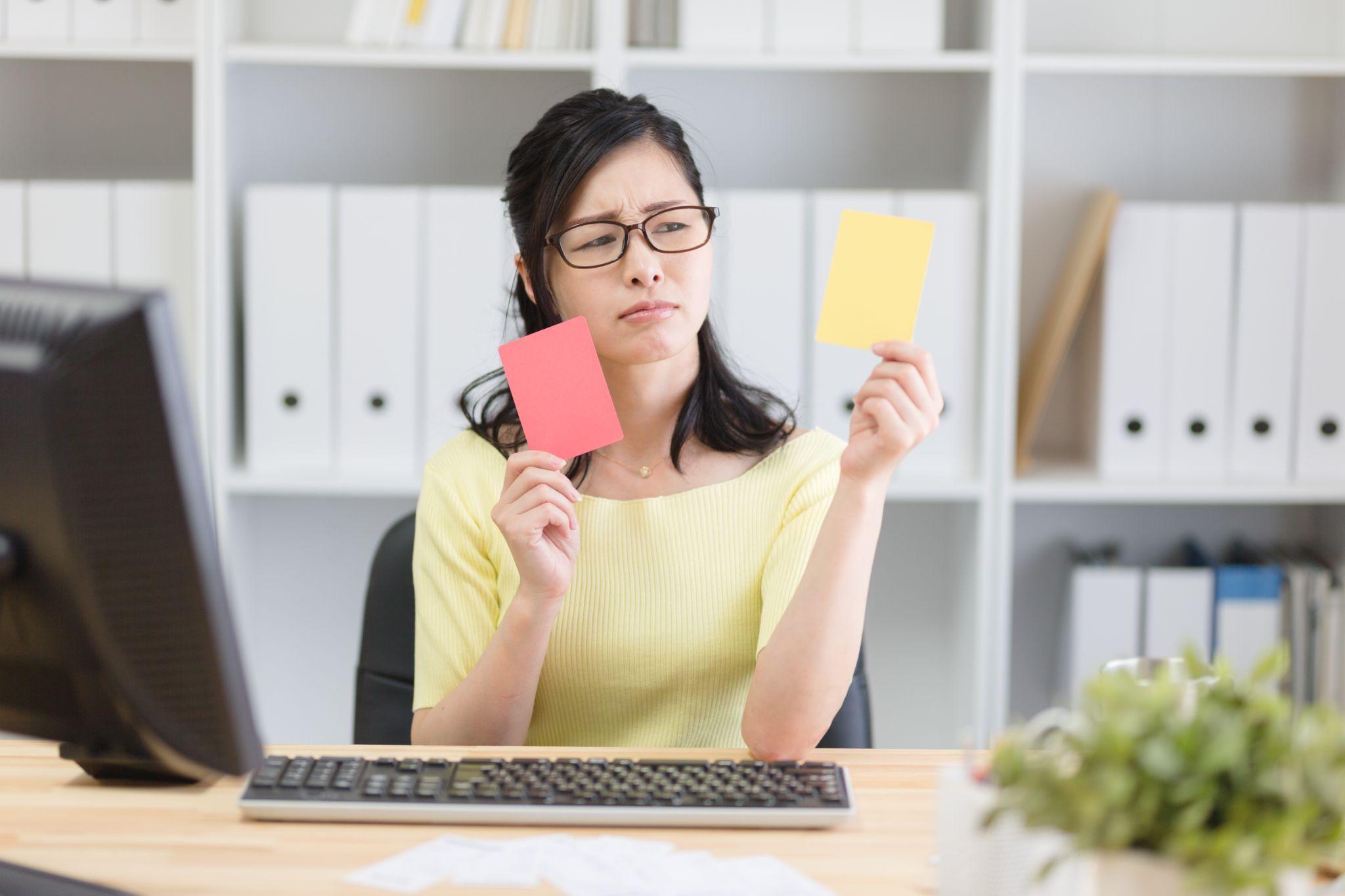 赤と黄のカードで悩む女性