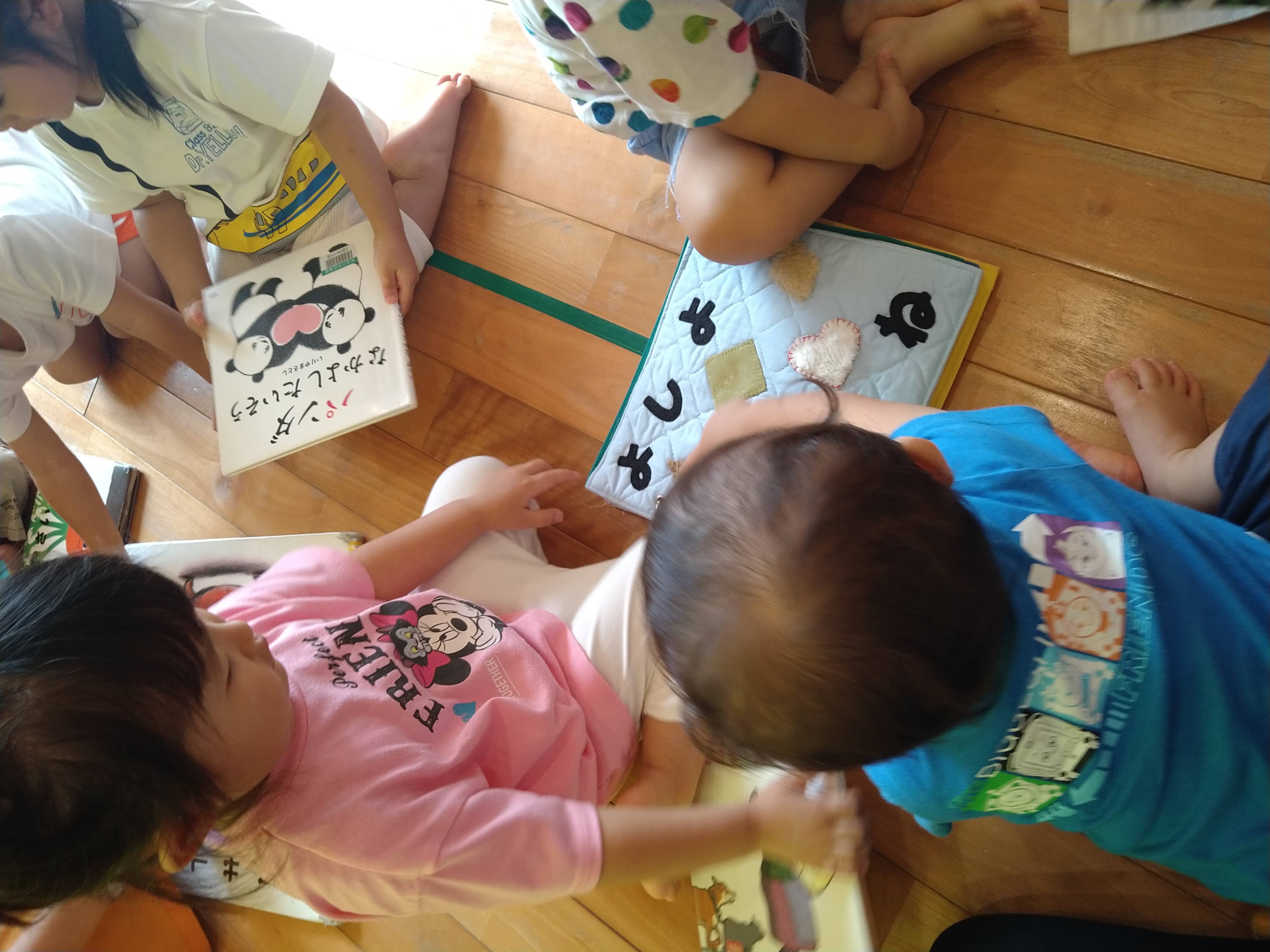 布絵本と絵本を囲み読みたい一冊を選ぶ子どもたち