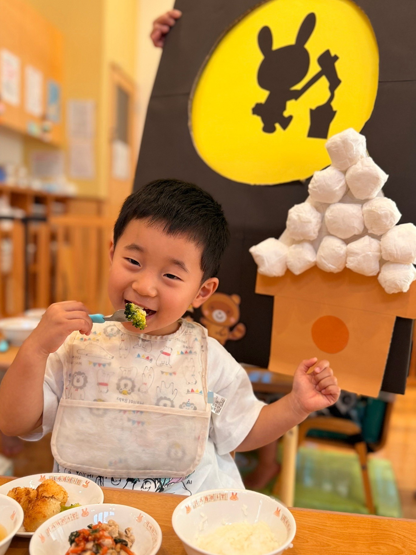 月とうさぎの飾りの前で食事を味わう子ども