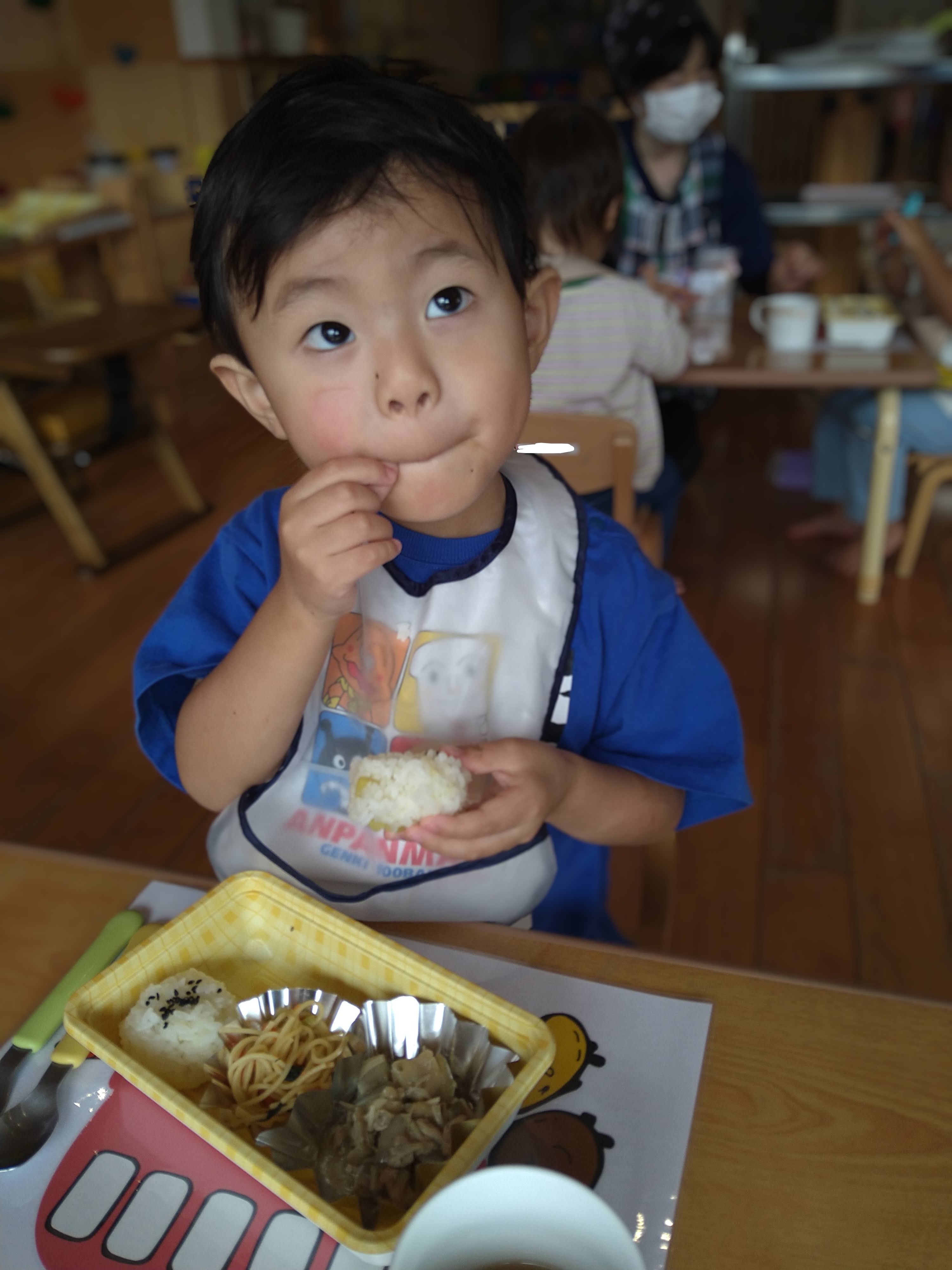 おにぎりを両手で持って味わう子ども