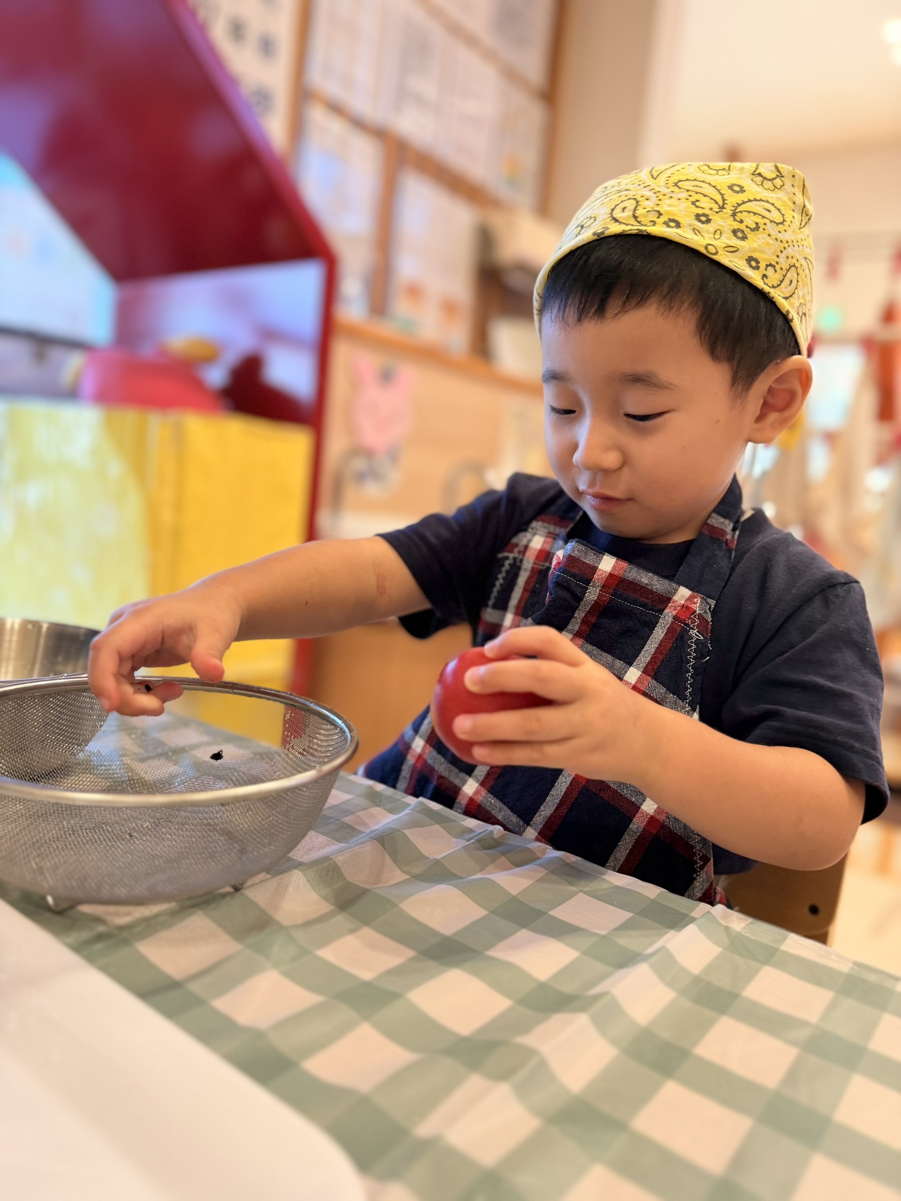 トマトとざるを持ち活動の手順を進める子ども