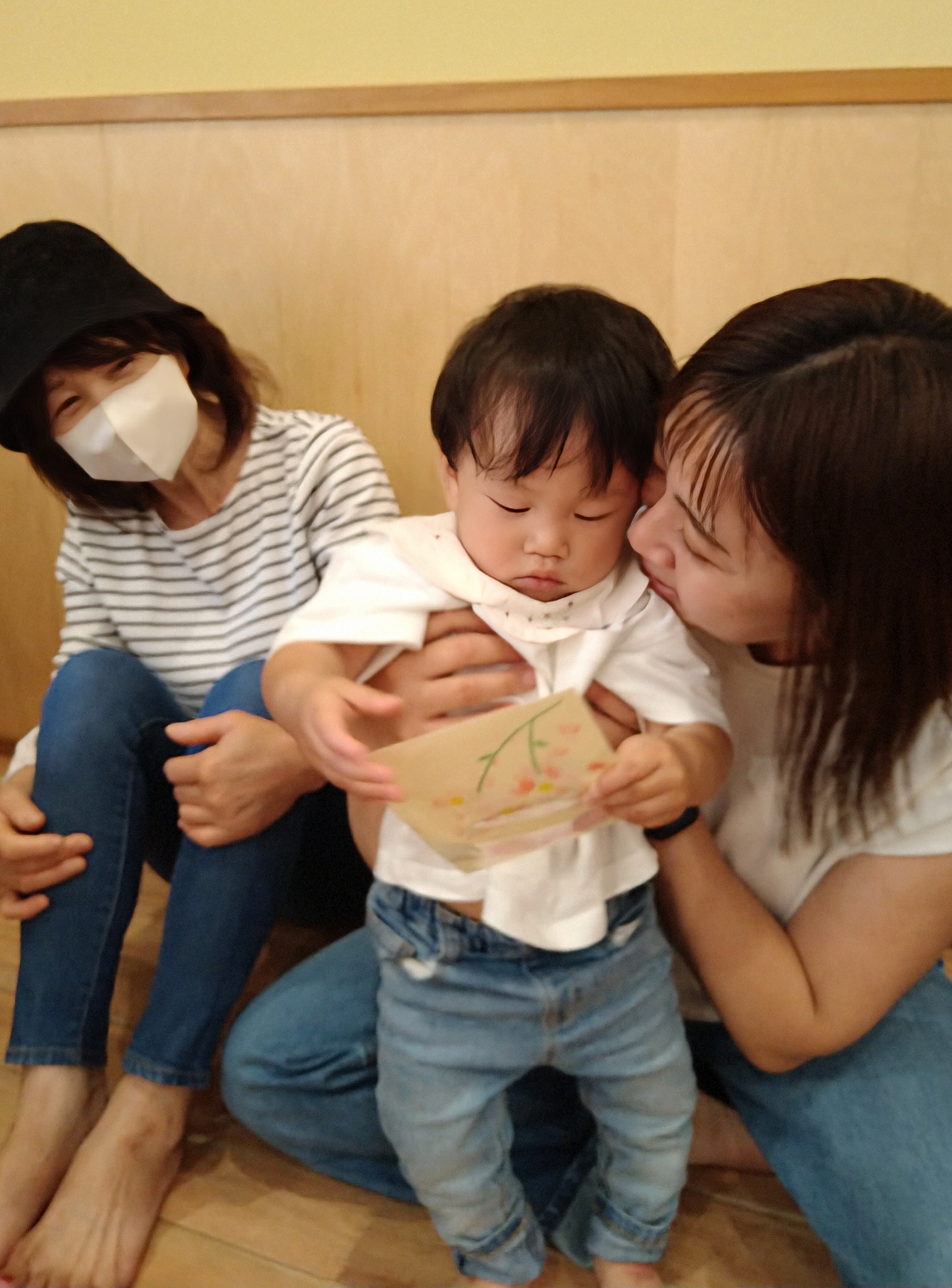 保護者と一緒に絵本を見て内容を確かめる子ども