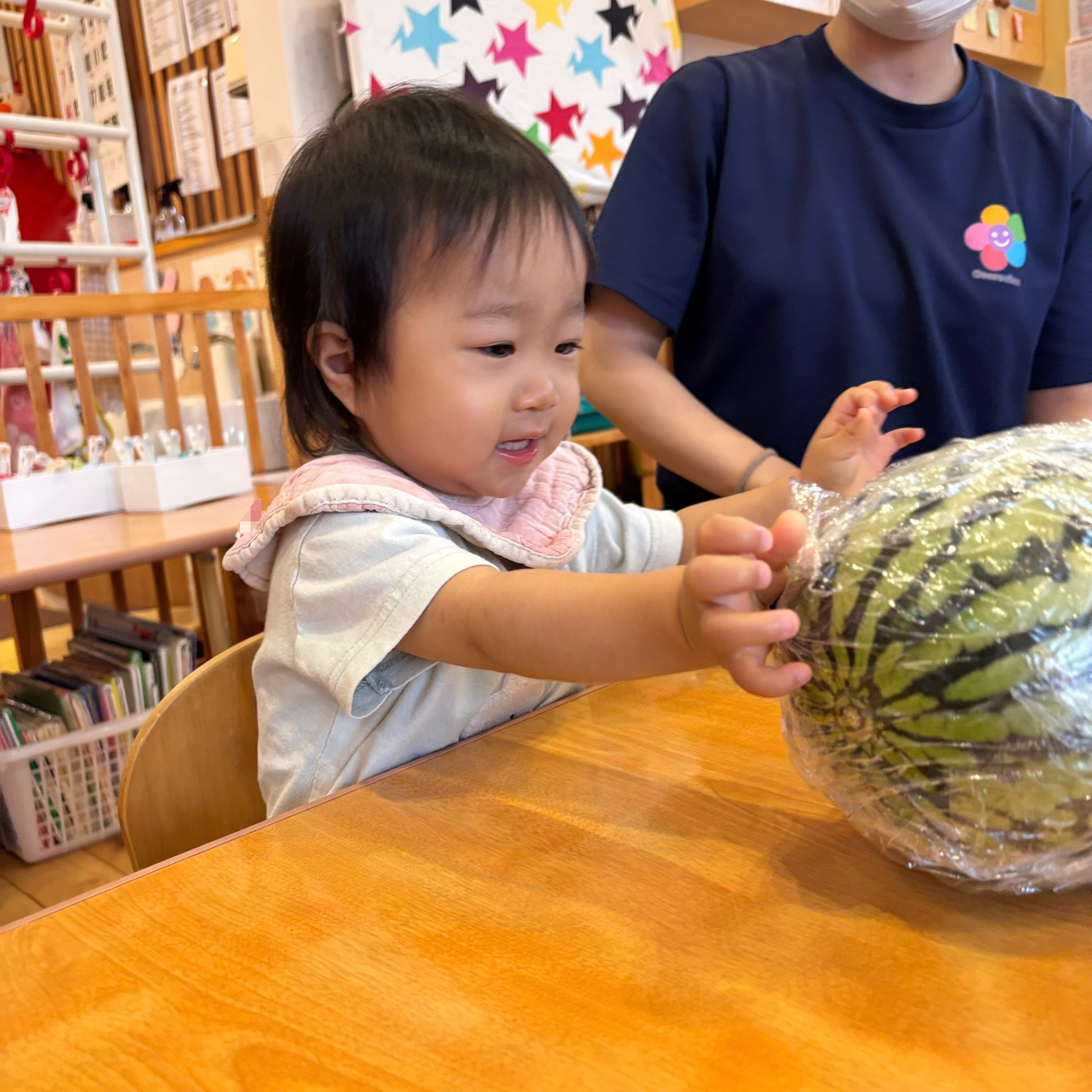 両手を伸ばしてすいかに触れる様子