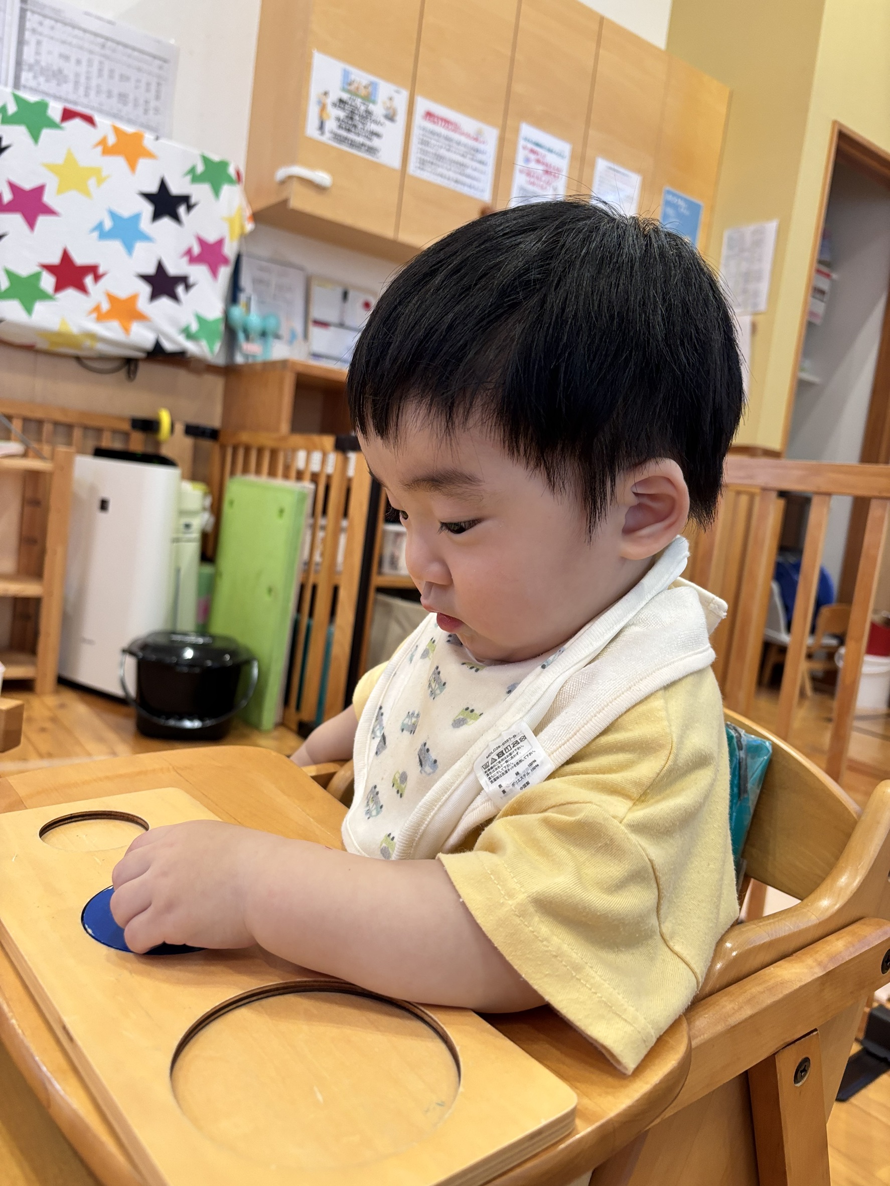 円形のピースを板のくぼみに合わせる様子