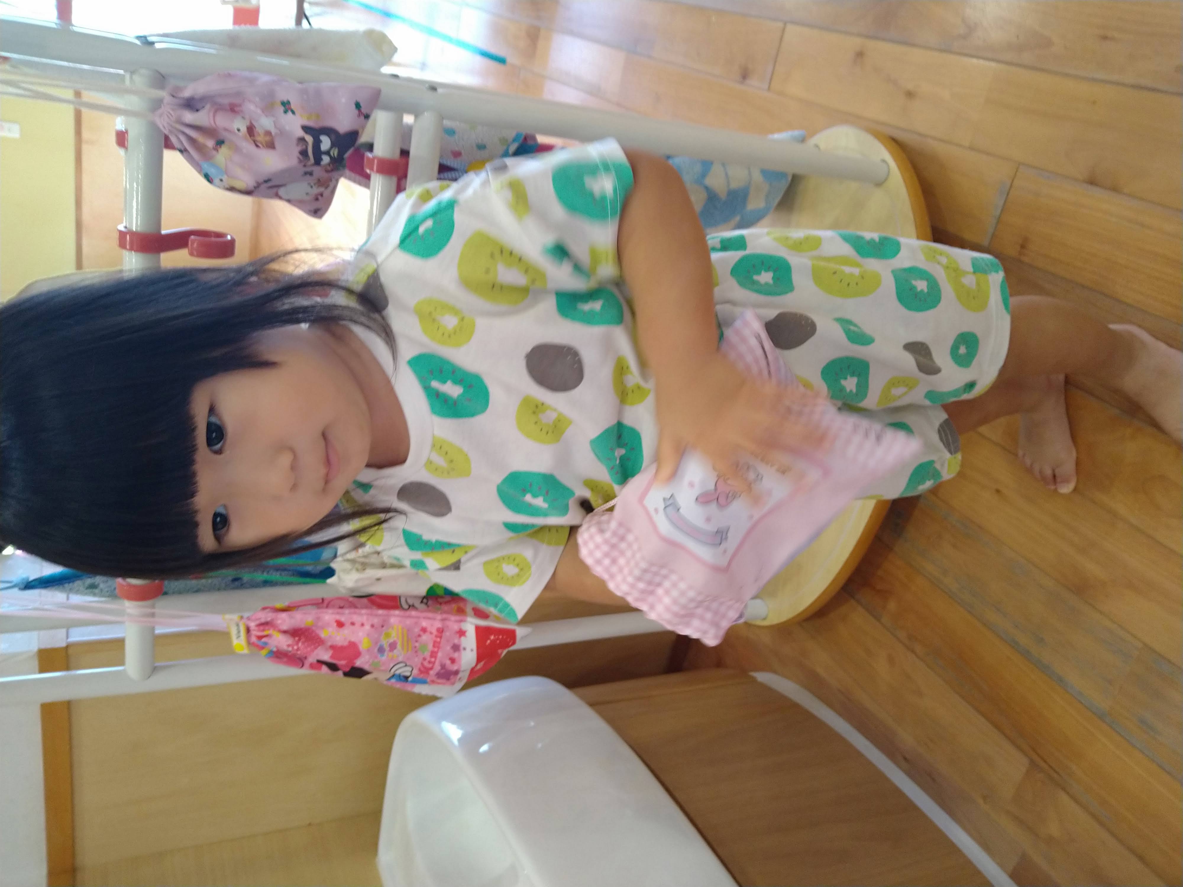 袋から取り出したコップを持つ子ども