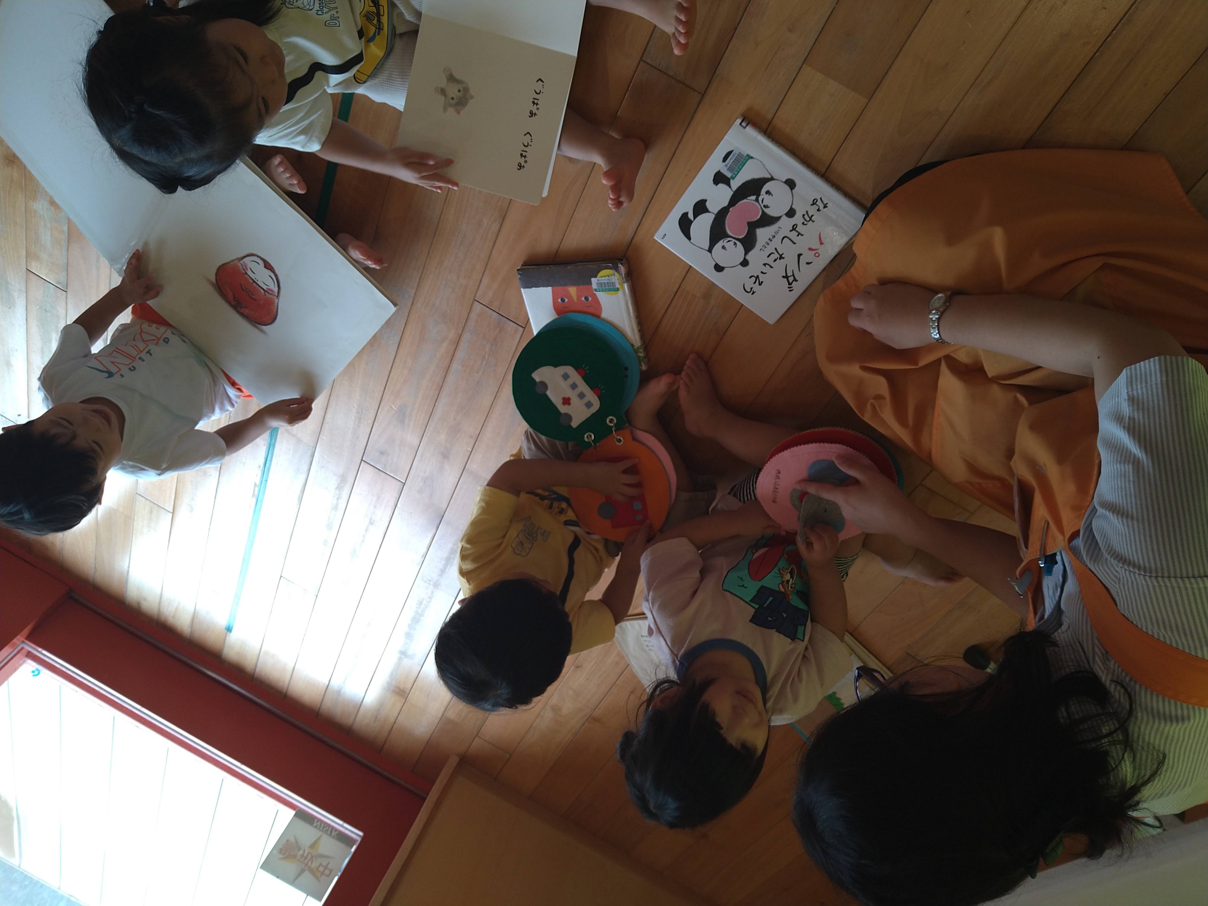 保育士と一緒に布絵本や絵本を楽しむ子どもたち
