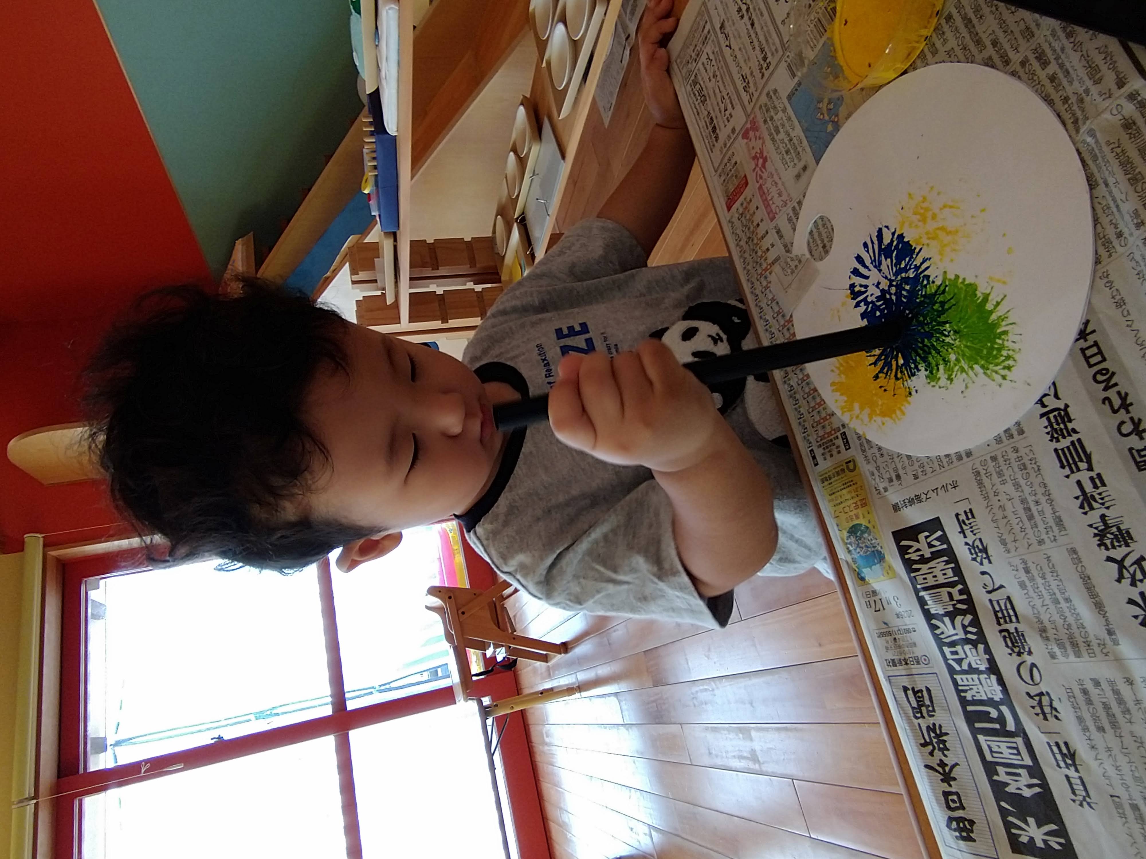 青や緑などの模様を重ねた作品と子ども
