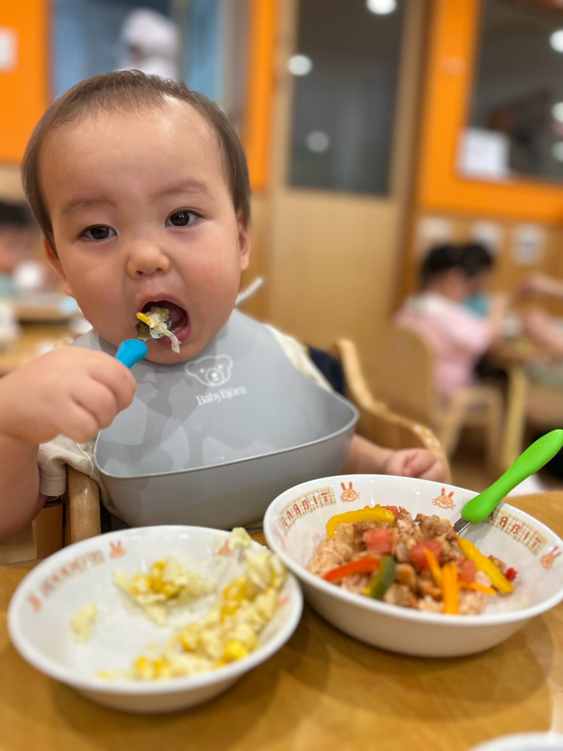 スプーンを持って自分で給食を食べる様子