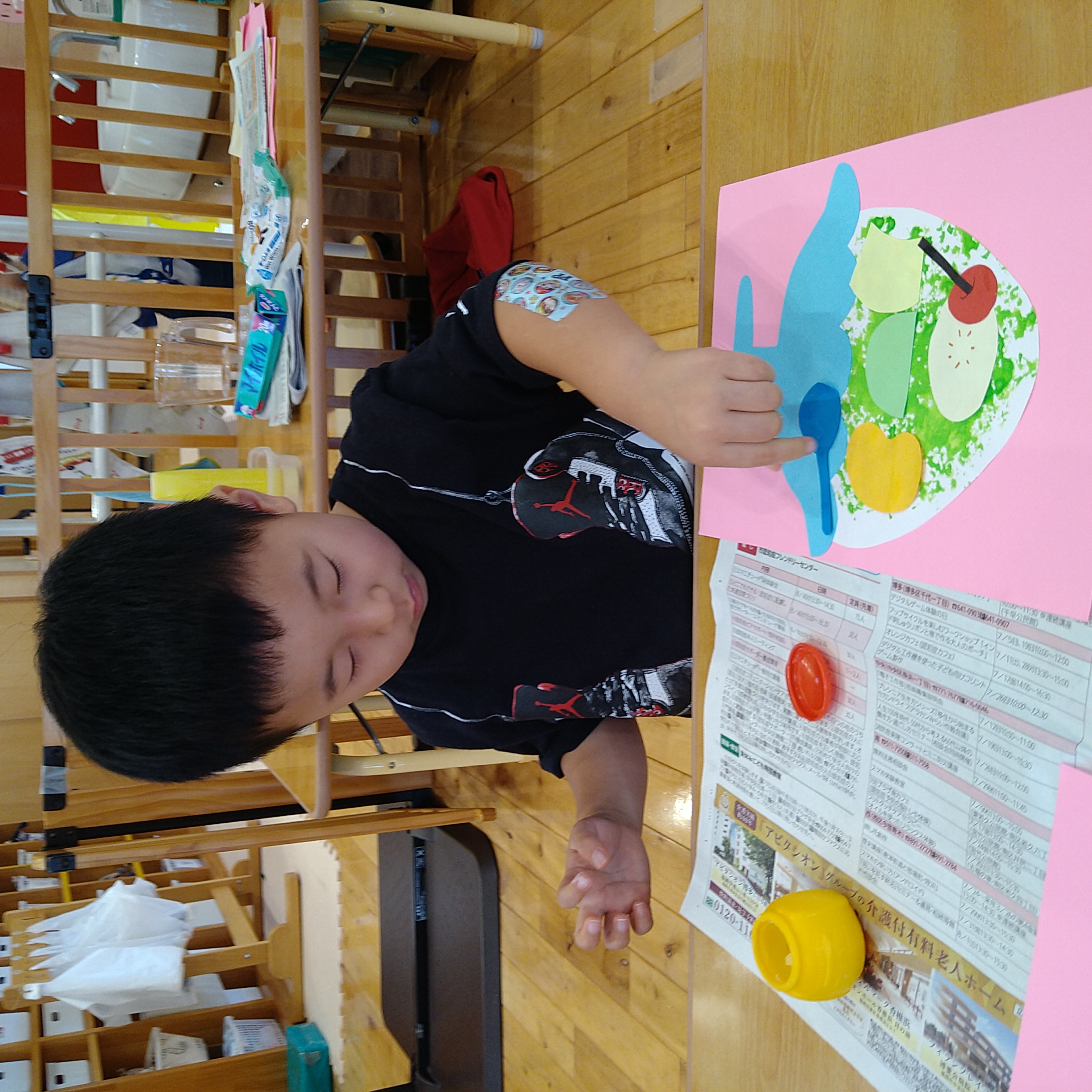 色紙の飾りを置いてかき氷の作品を仕上げる子ども