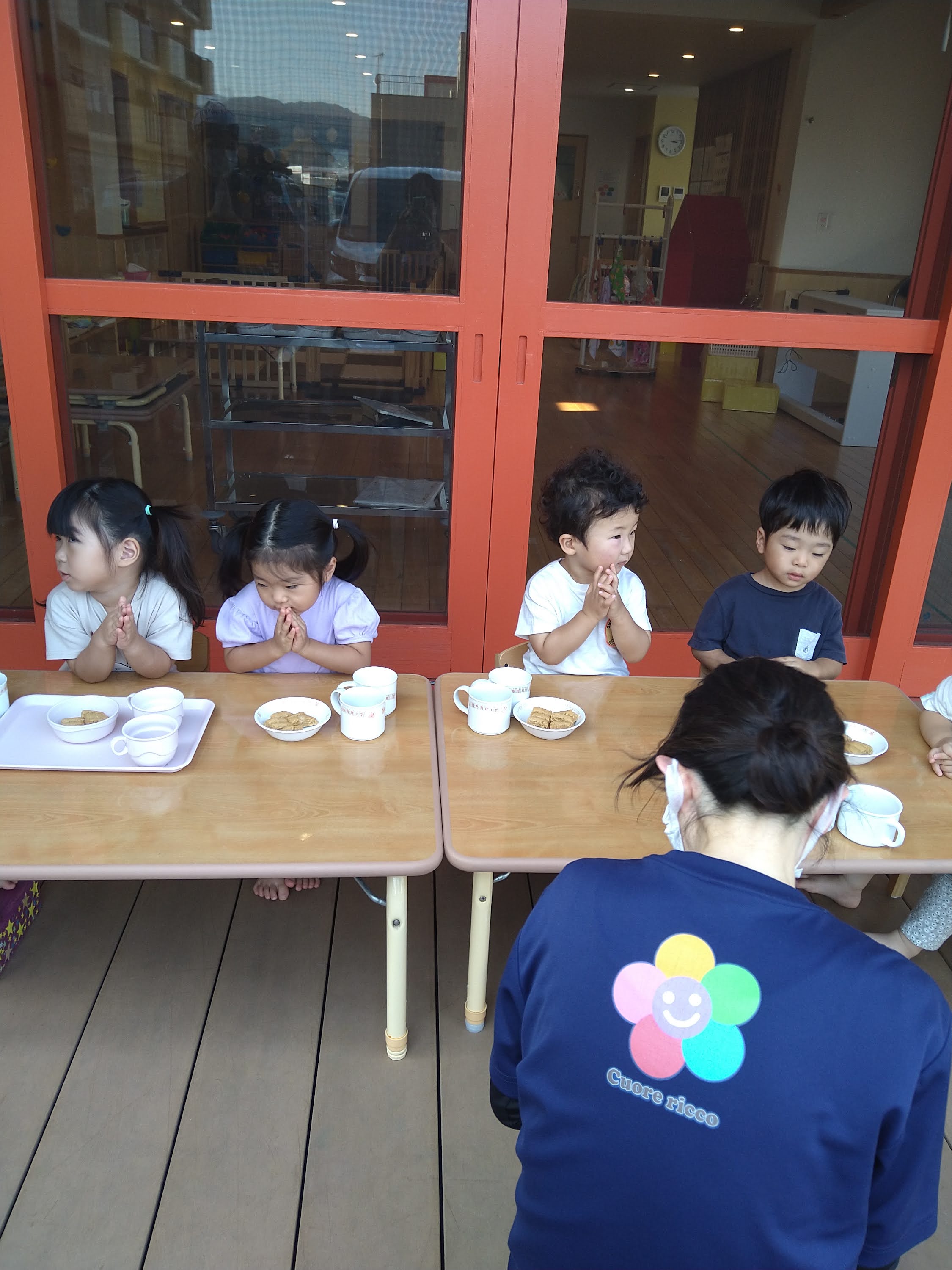 おやつを前に手を合わせる子どもたち