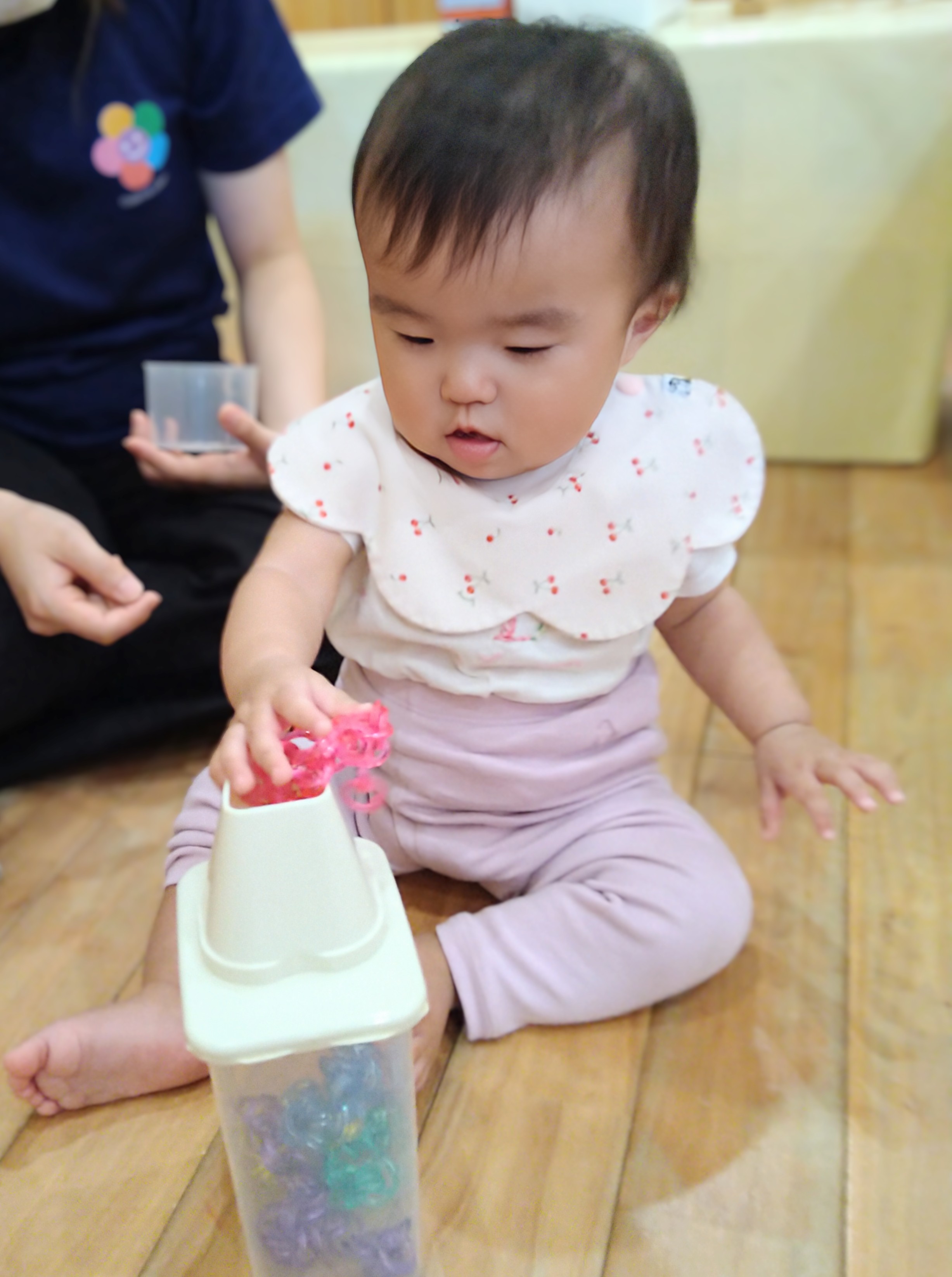 色のついた輪を容器へ入れようとする子ども